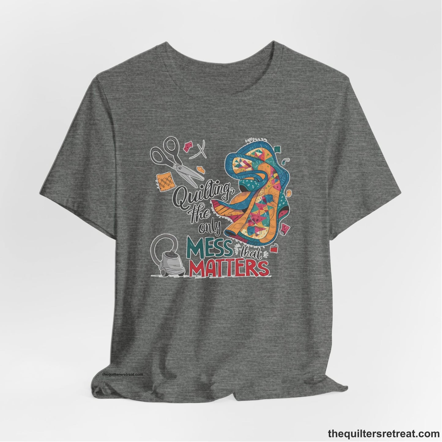A Deep Heather Short Sleeve T-Shirt with a quilting tools and patchwork pieces with bold "Quilting, the only mess that matters" text