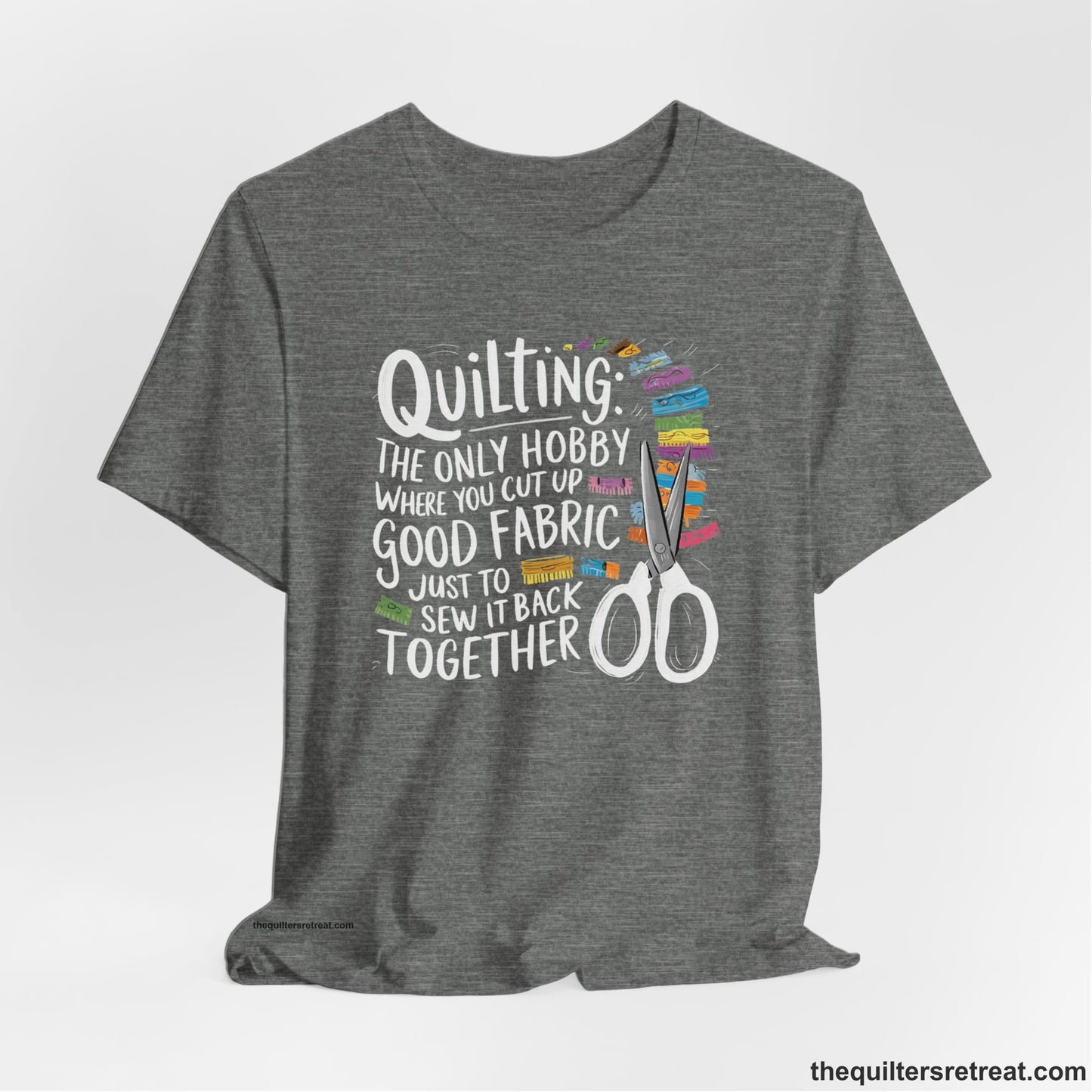A Deep Heather Short Sleeve T-Shirt with a quilting-themed text with colorful fabric pieces and scissors in a whimsical style
