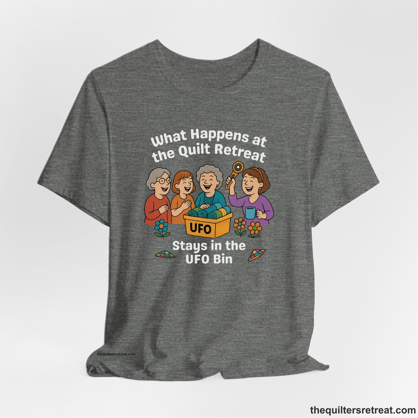 A Deep Heather Short Sleeve T-Shirt with a four smiling women with unfinished fabric objects and playful "UFO" text in a cartoon style