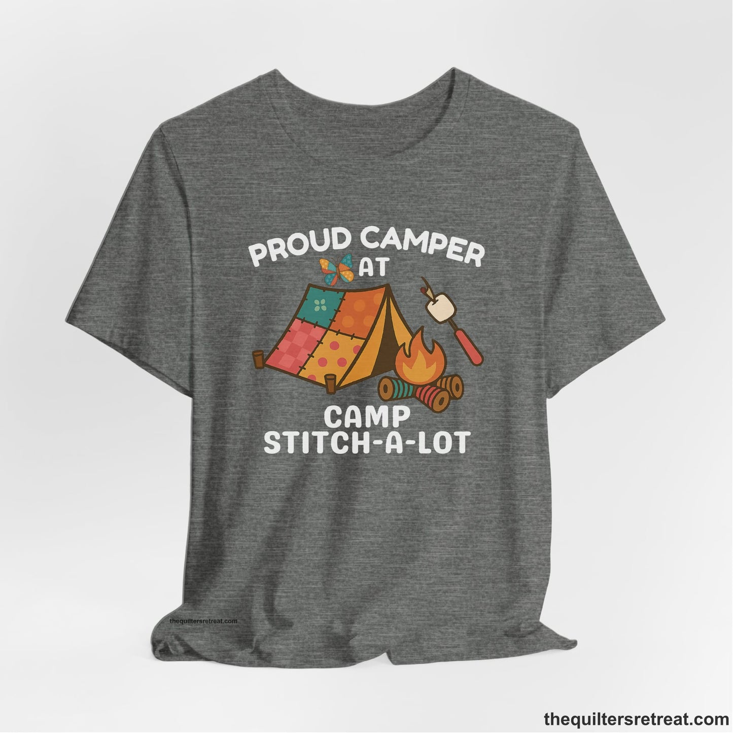 A Deep Heather Short Sleeve T-Shirt with a camping scene with patchwork tent, campfire, and whimsical butterfly and marshmallow illustration
