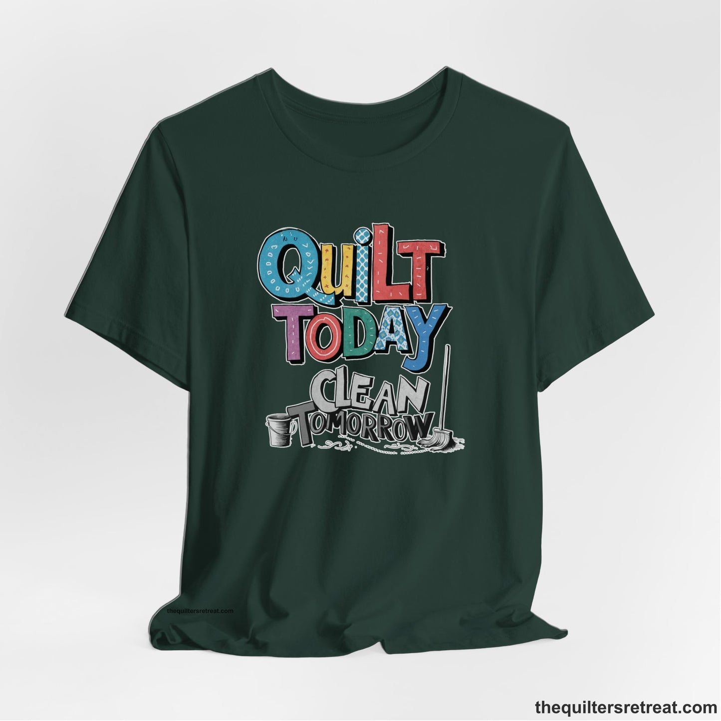 A Forest Short Sleeve T-Shirt with a playful "Quilt Today Clean Tomorrow" text with colorful patterns and cleaning tools illustration