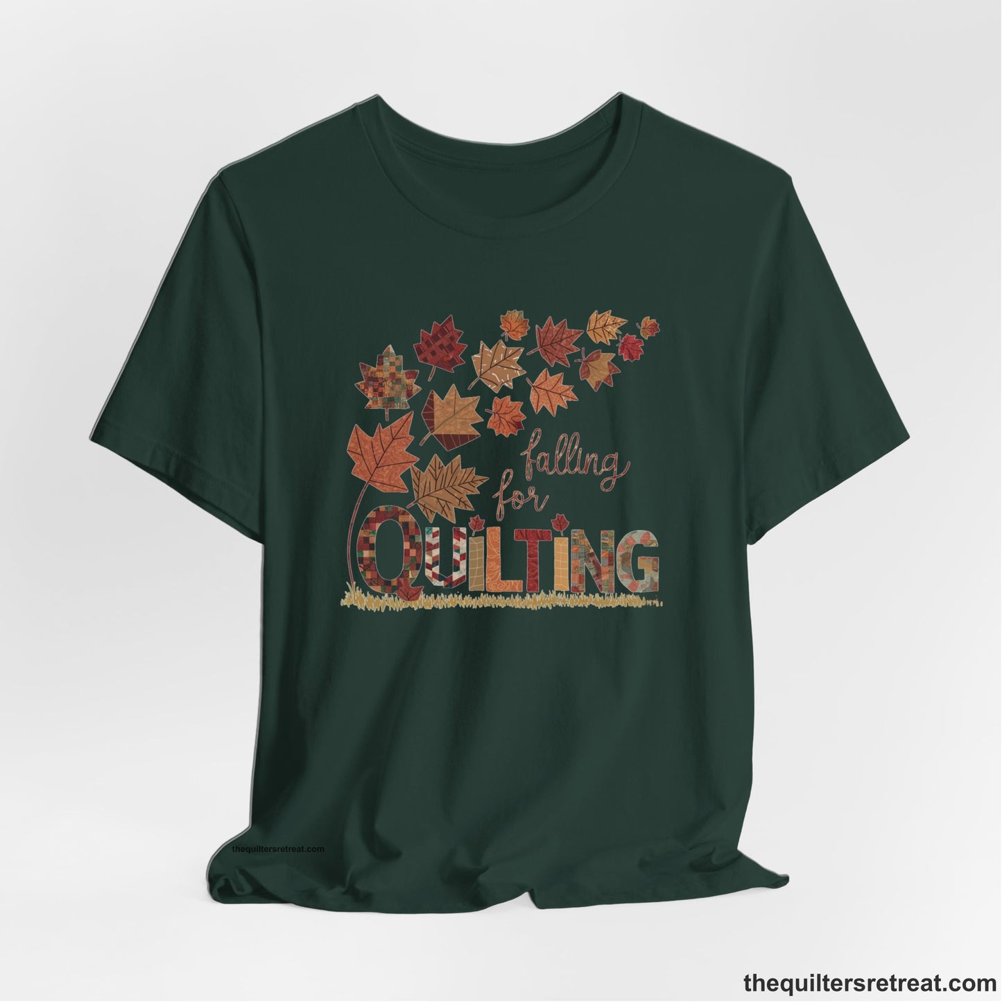 A Forest Short Sleeve T-Shirt with a falling autumn leaves and "Falling for Quilting" text in a patchwork style