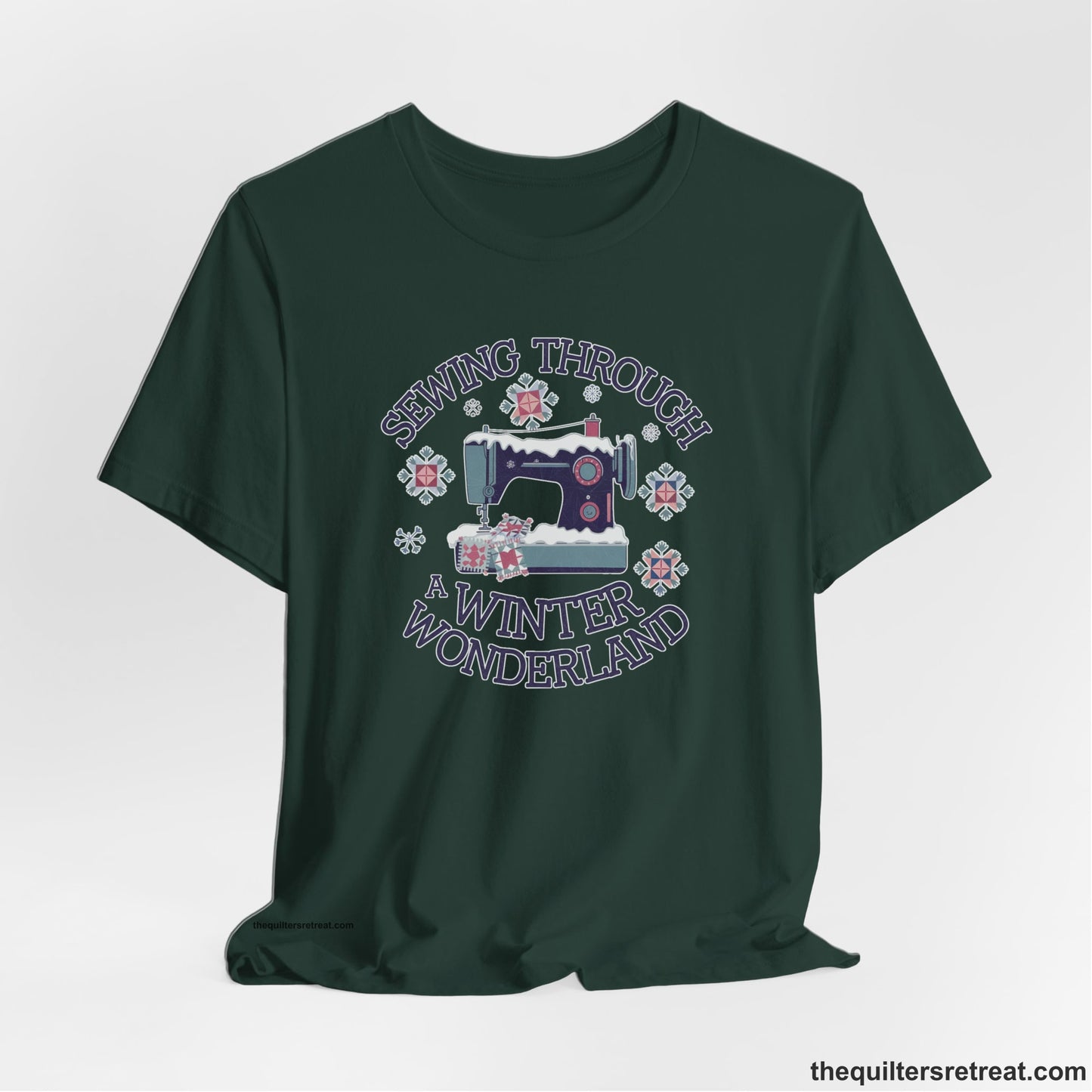 A Forest Short Sleeve T-Shirt with a sewing machine covered in snow with festive quilting elements and "Sewing Through a Winter Wonderland" text