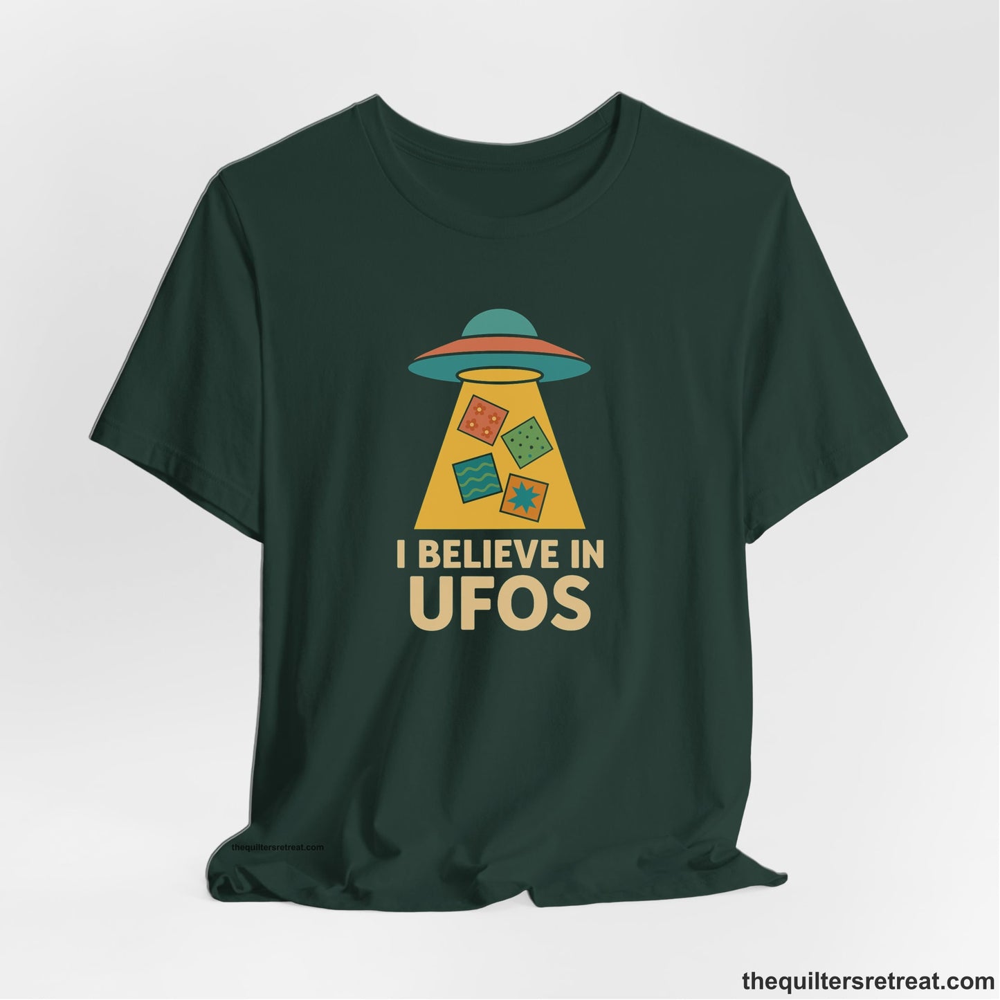 A Forest Short Sleeve T-Shirt with a colorful UFO with quilt patterns and bold "I Believe in UFOs" text in retro style