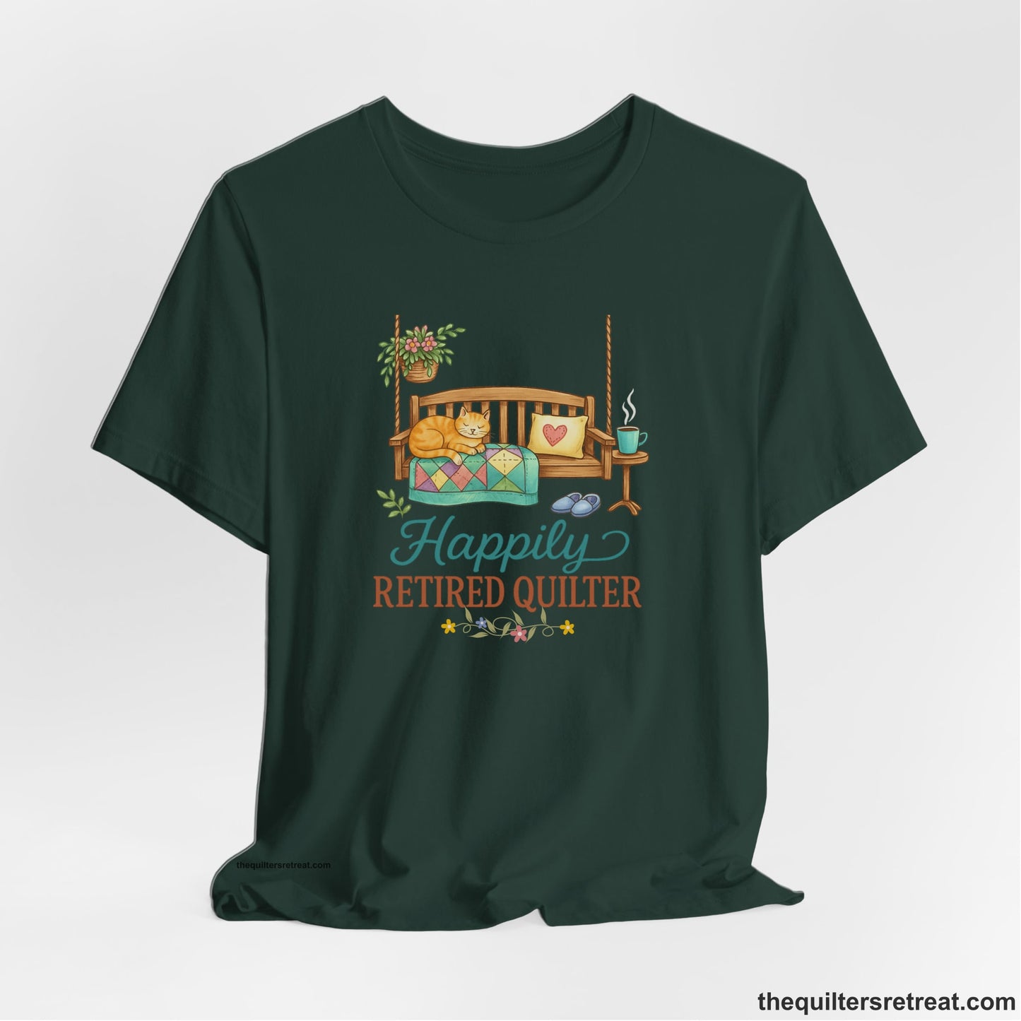 A Forest Short Sleeve T-Shirt with a hanging bench with cozy cat and quilt, surrounded by plants, "Happily Retired Quilter" text