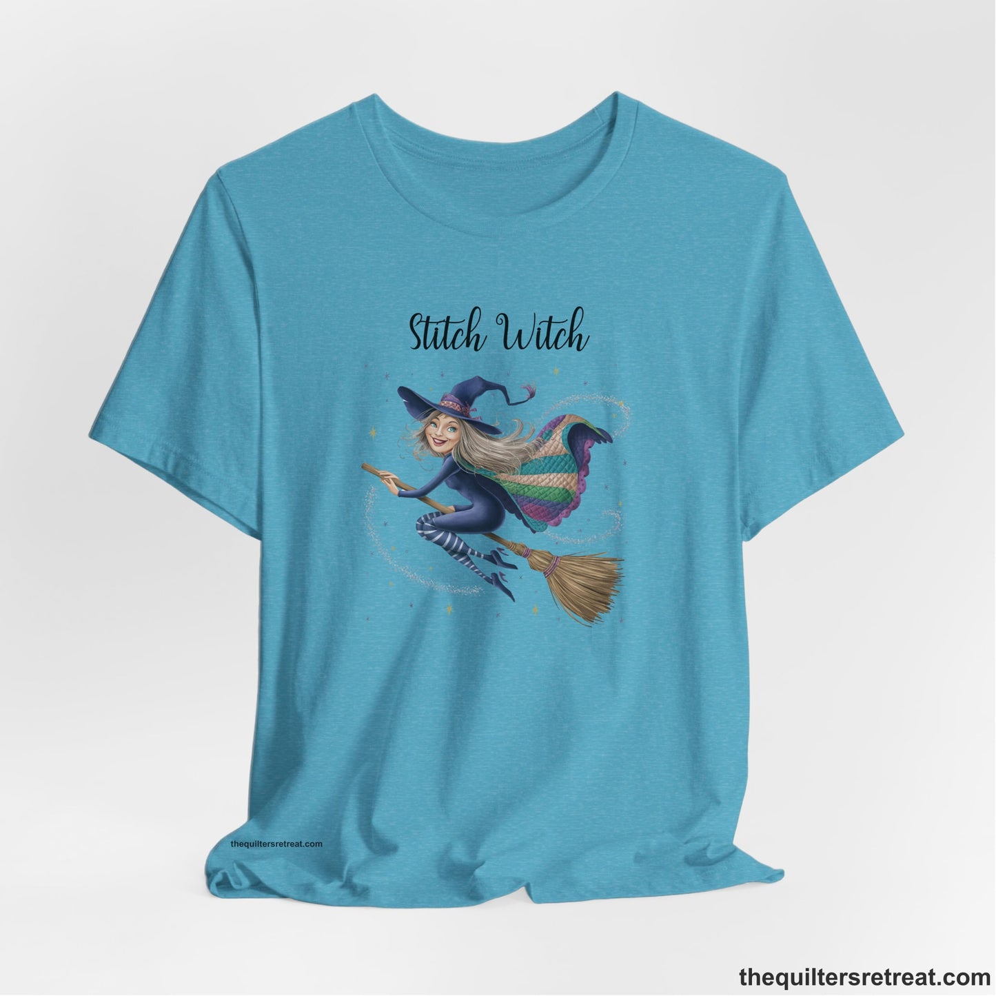 A Heather Aqua Short Sleeve T-Shirt with a playful witch on broomstick with patchwork cape and starry background in a whimsical style