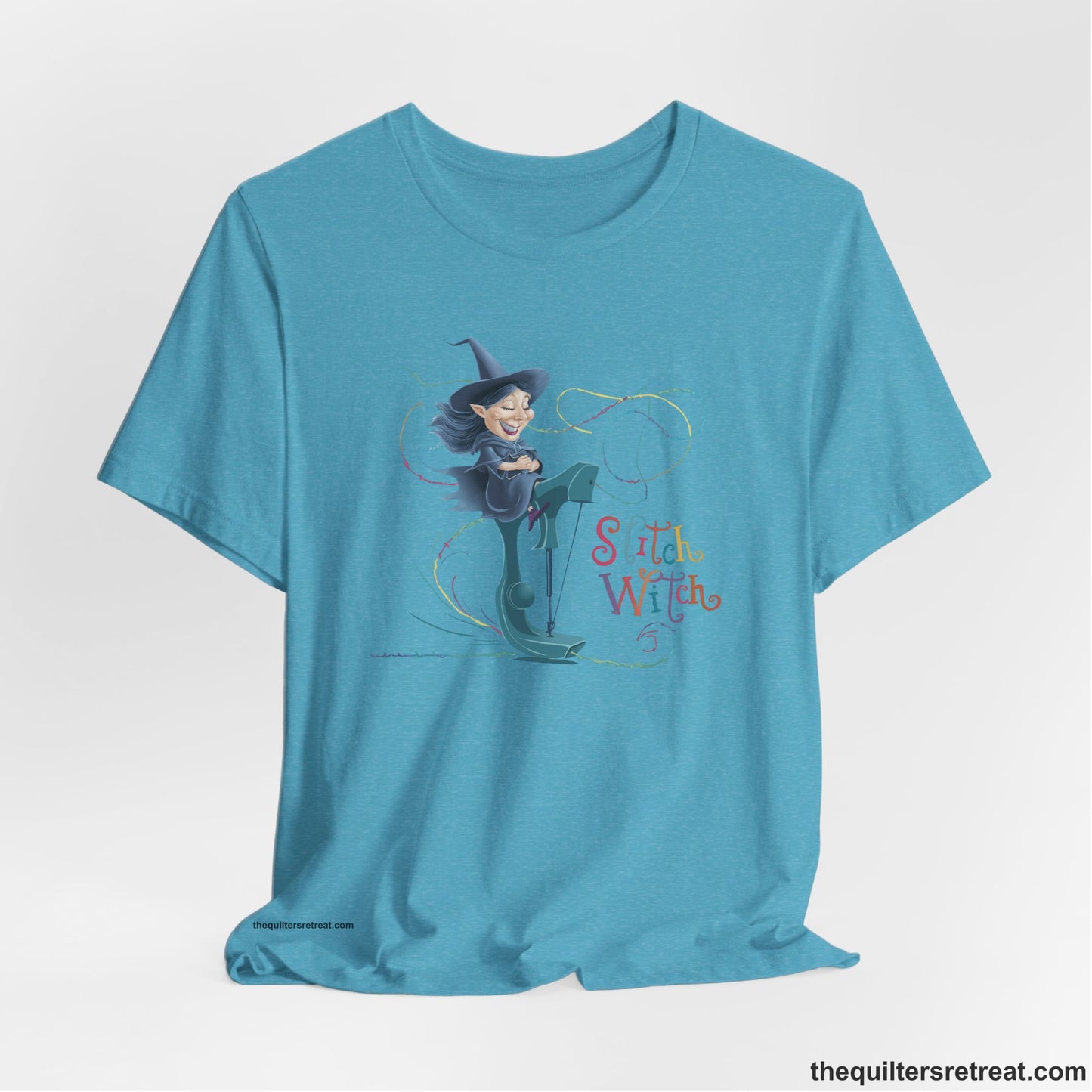 A Heather Aqua Short Sleeve T-Shirt with a witch on vintage sewing machine with "Stitch Witch" text in playful, colorful style