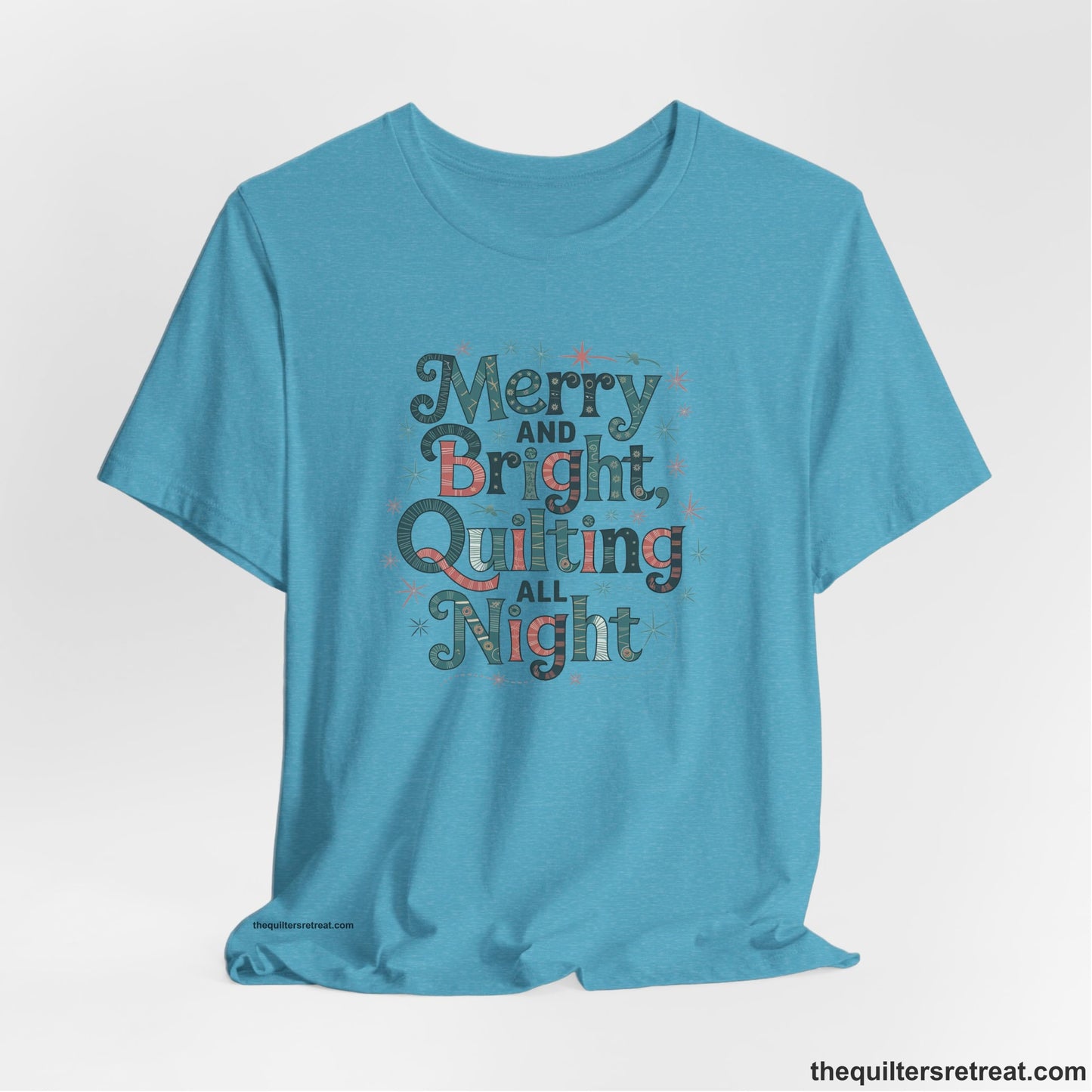 A Heather Aqua Short Sleeve T-Shirt with a Merry and Bright Quilting All Night text with festive patterns and stars in a whimsical style