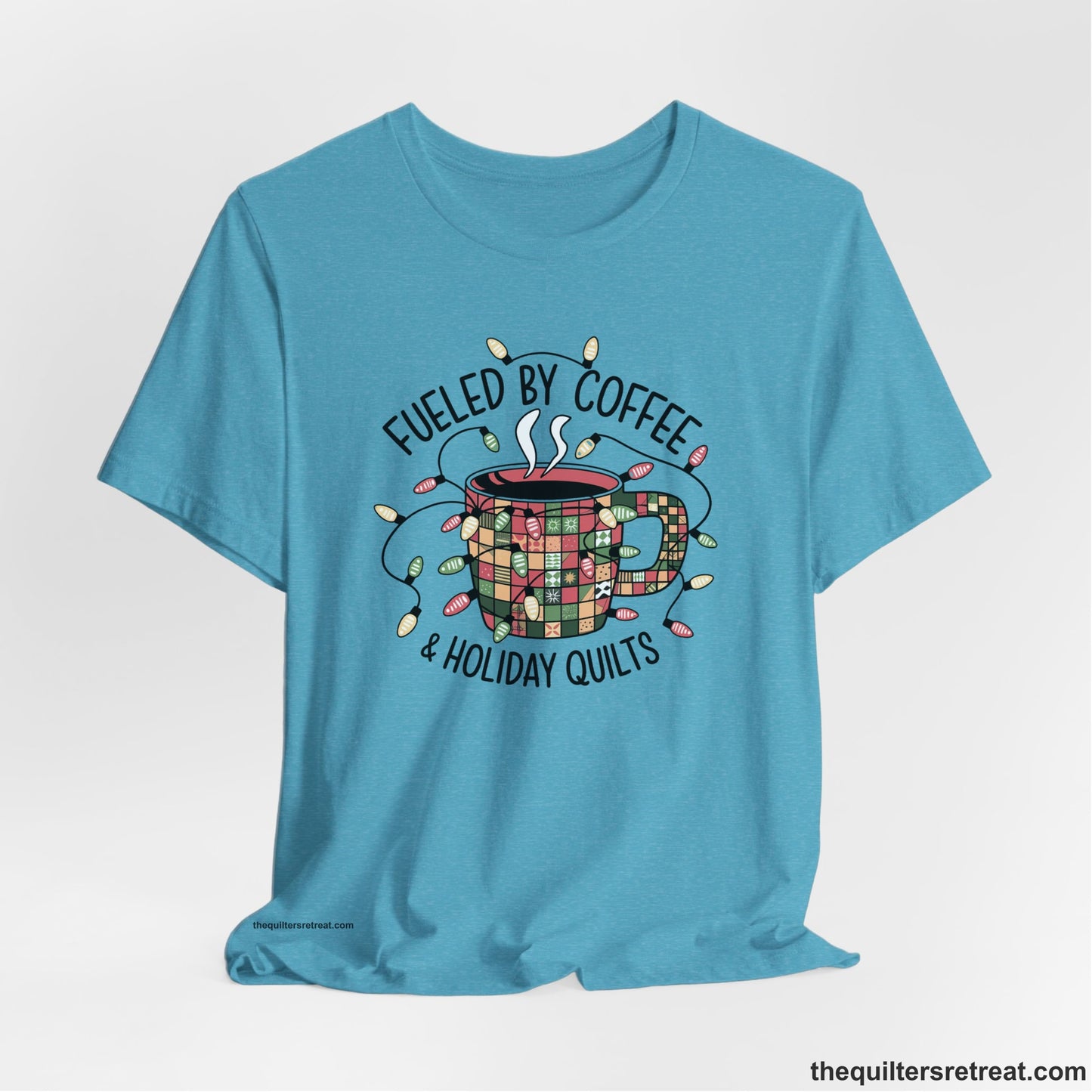 A Heather Aqua Short Sleeve T-Shirt with a patchwork coffee mug with colorful lights and subtle "Fueled by Coffee" text in festive style