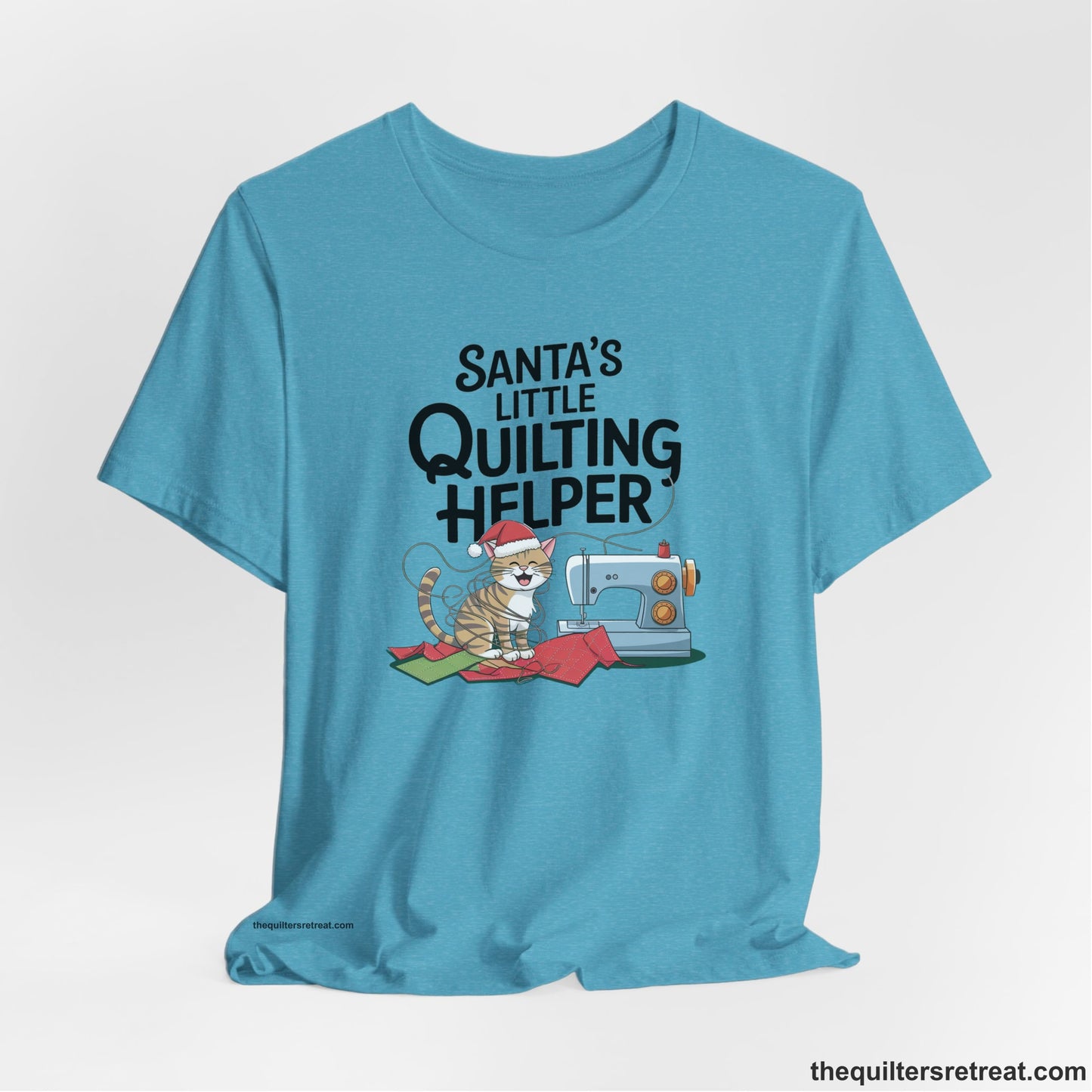 A Heather Aqua Short Sleeve T-Shirt with a santa-hat-wearing kitten with a sewing machine and "Santa's Little Quilting Helper" text in playful style