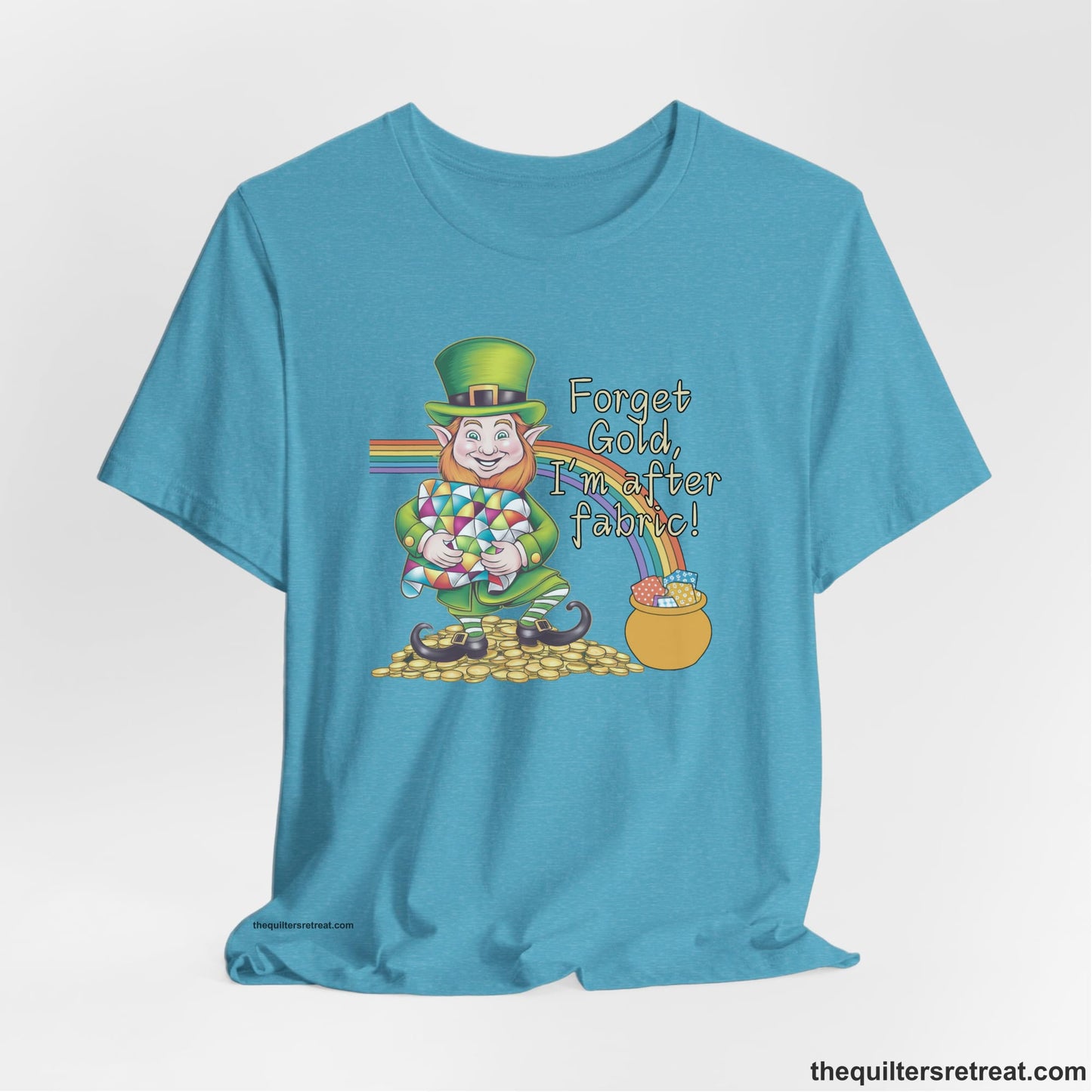 A Heather Aqua Short Sleeve T-Shirt with a leprechaun with colorful quilt and rainbow, whimsical "Forget Gold, I'm after fabric!" text