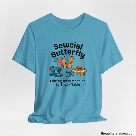 A Heather Aqua Short Sleeve T-Shirt with a playful butterfly near sewing machine with cookies and coffee doodle design