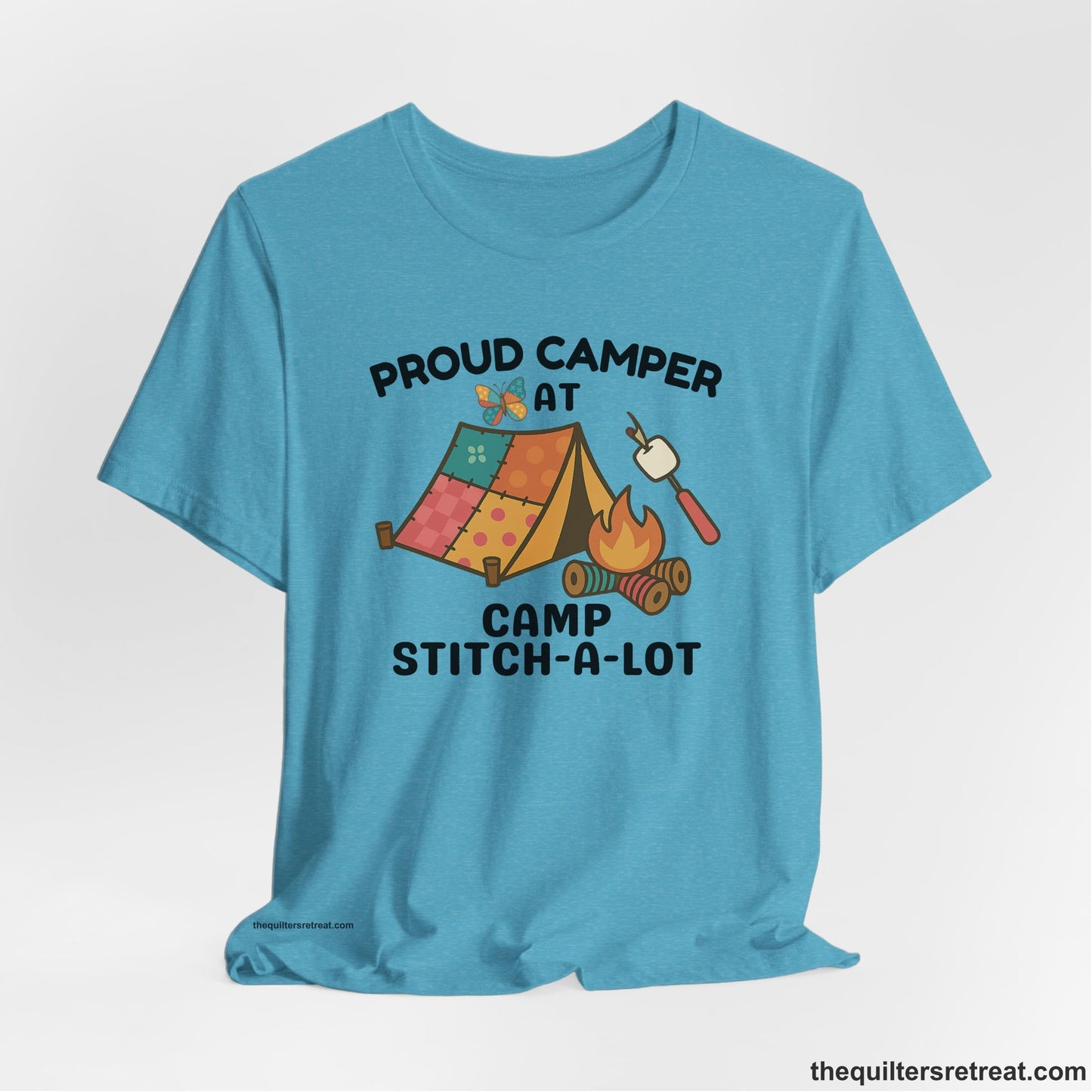A Heather Aqua Short Sleeve T-Shirt with a camping scene with patchwork tent, campfire, and whimsical butterfly and marshmallow illustration