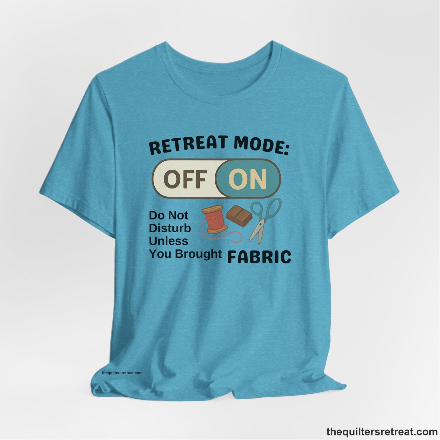 A Heather Aqua Short Sleeve T-Shirt with a illustration of sewing tools with a playful "OFF ON" switch design