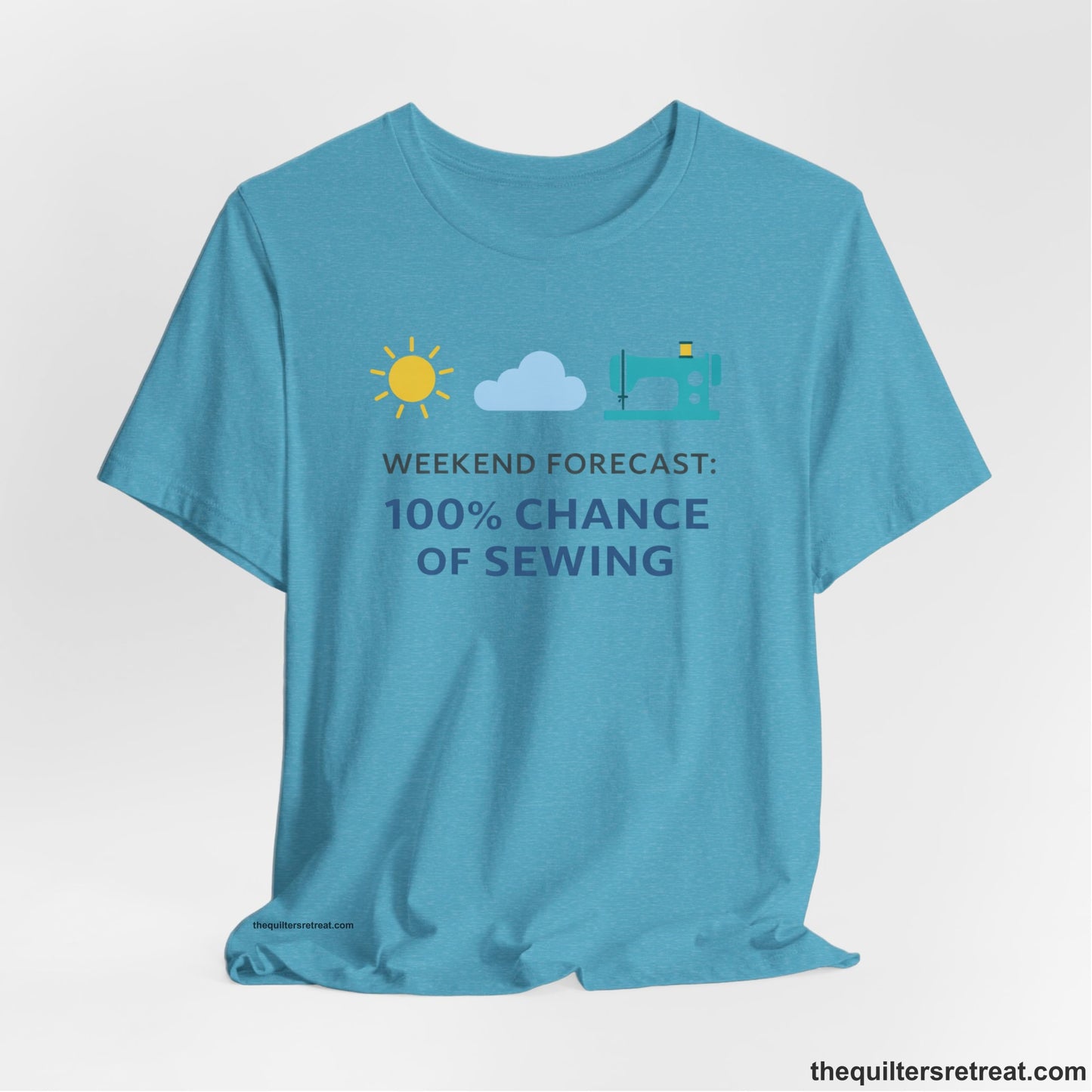 A Heather Aqua Short Sleeve T-Shirt with a Sun, cloud, sewing machine icons; bold text "Weekend Forecast: 100% Chance of Sewing"; playful style.