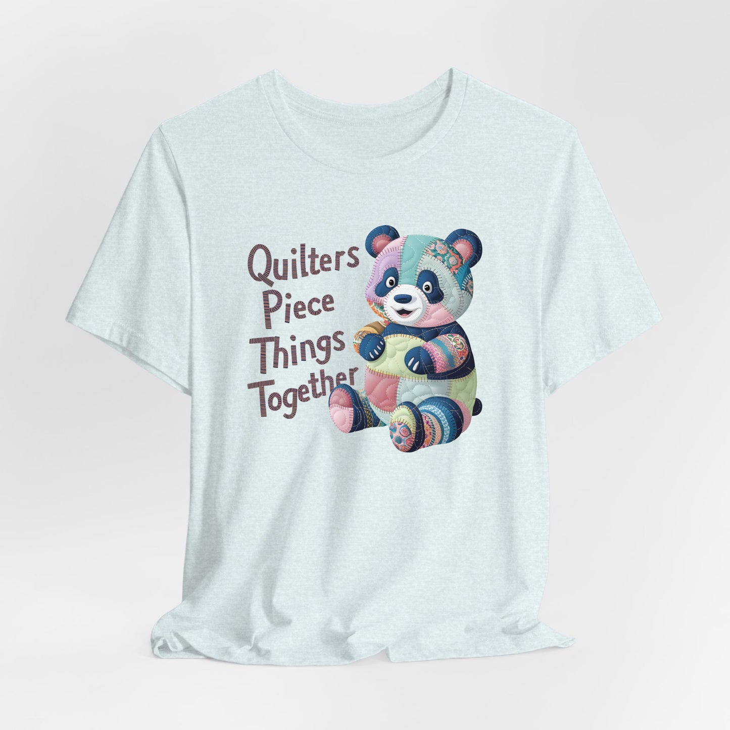 A Heather Ice Blue Short Sleeve T-Shirt with a patchwork panda with "Quilters Piece Things Together" text in a whimsical style