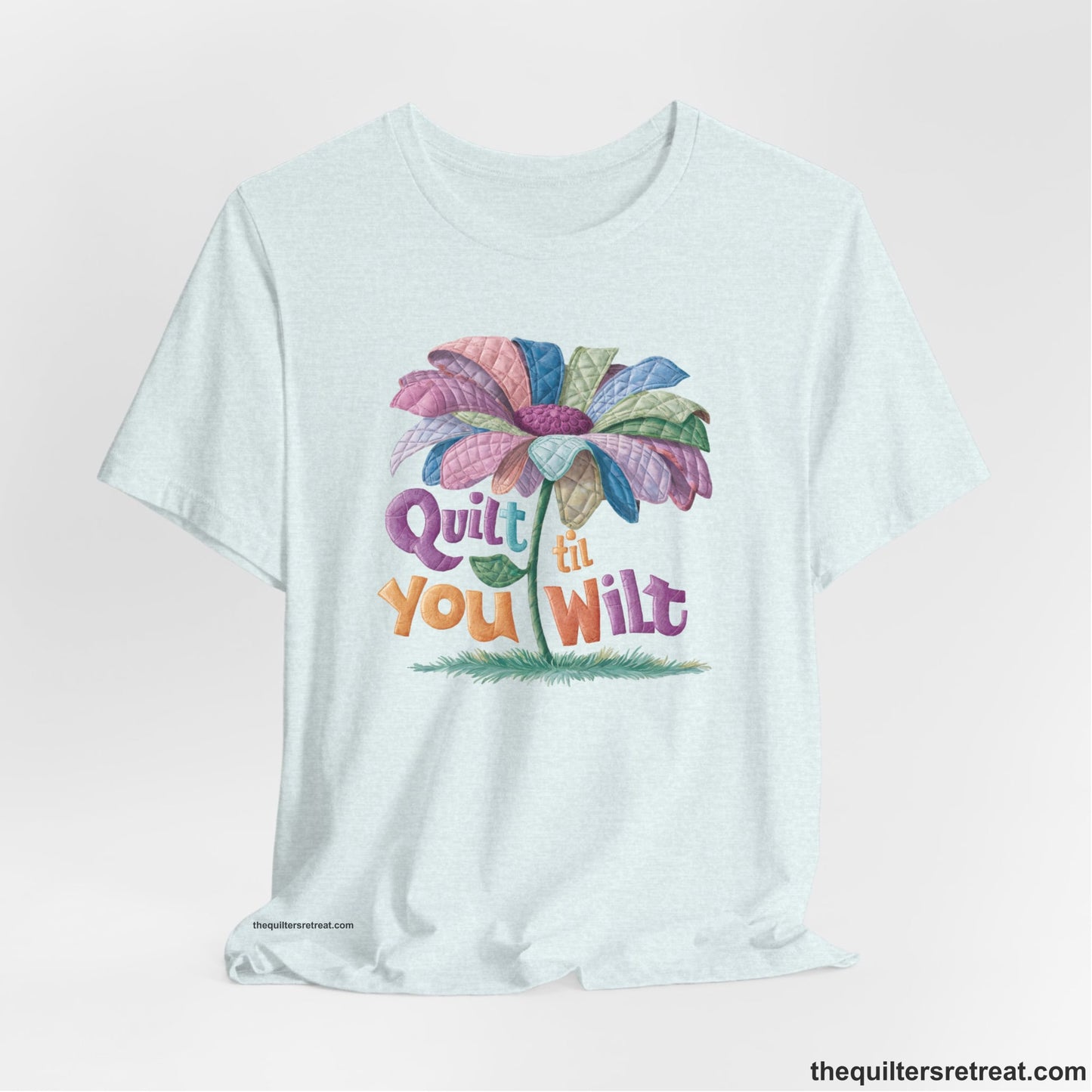 A Heather Ice Blue Short Sleeve T-Shirt with a whimsical quilted flower with bold "Quilt til You Wilt" text