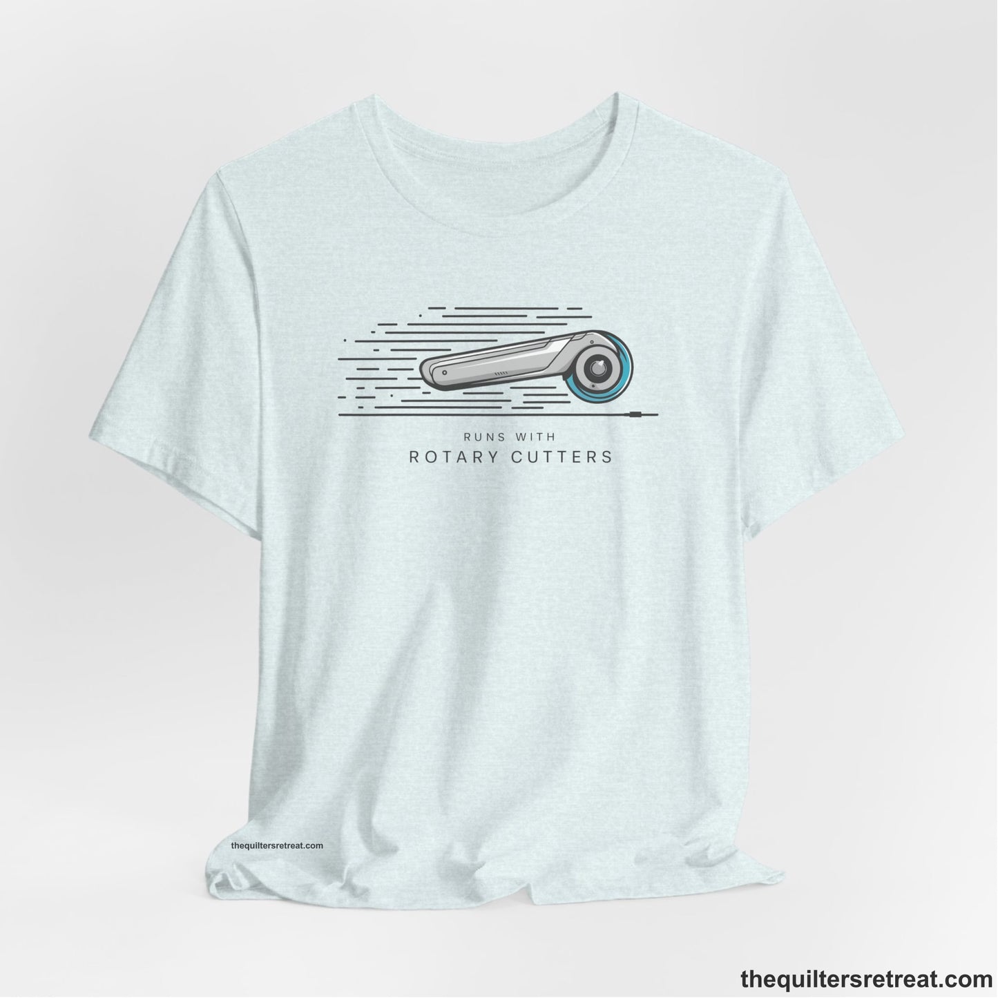 A Heather Ice Blue Short Sleeve T-Shirt with a rotary cutter illustration with dynamic lines and bold "Runs with Rotary Cutters" text