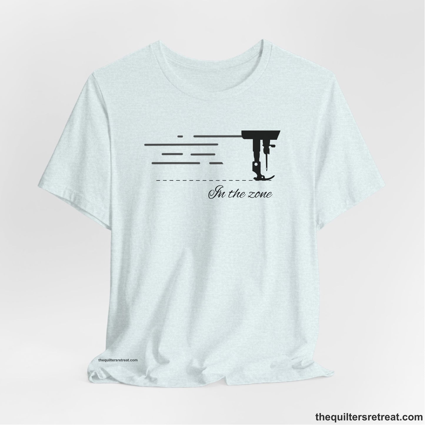 A Heather Ice Blue Short Sleeve T-Shirt with a vintage sewing machine illustration with floral accents and "Sewing Mends the Soul" text