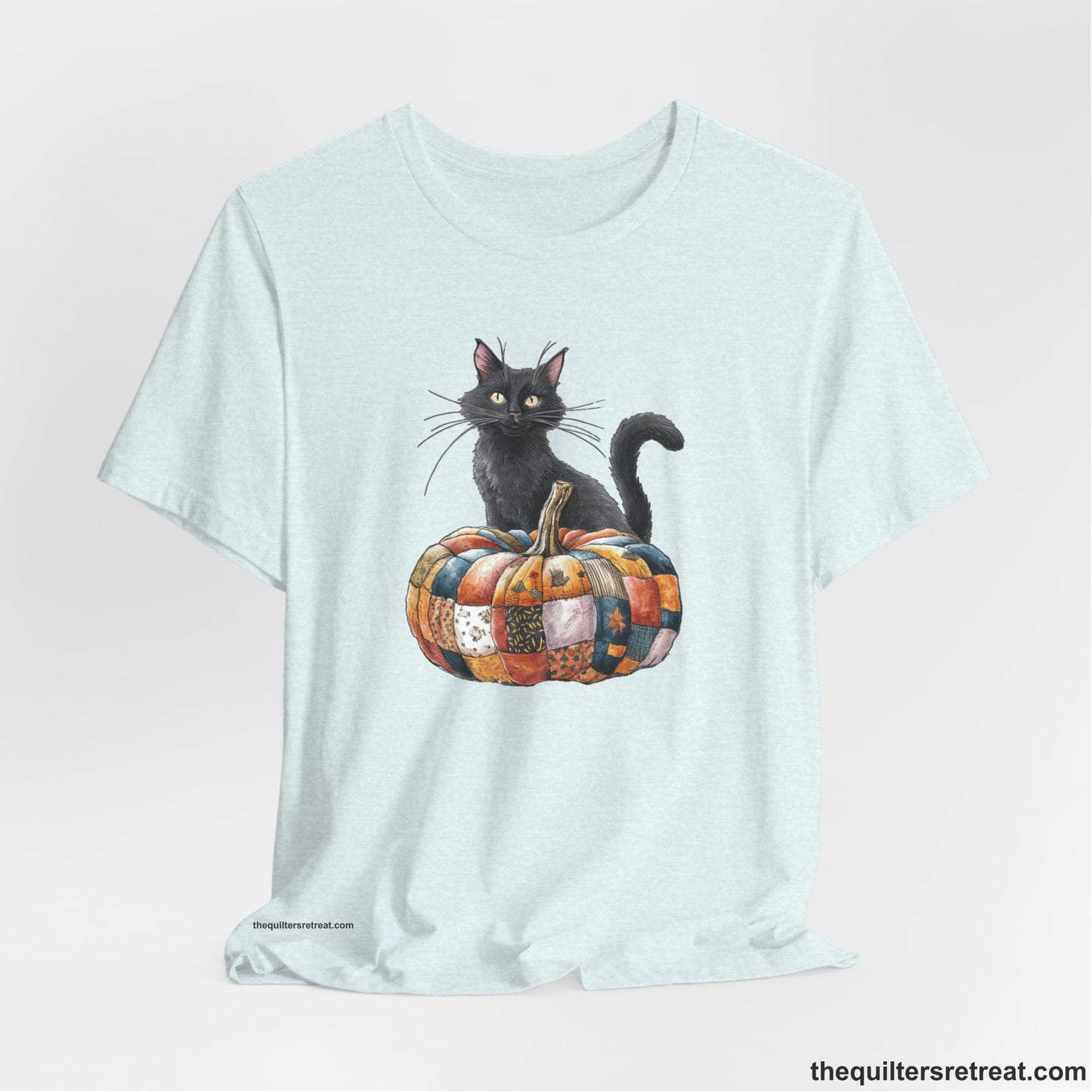 A Heather Ice Blue Short Sleeve T-Shirt with a black cat with a quilted patchwork pumpkin in a whimsical autumn style