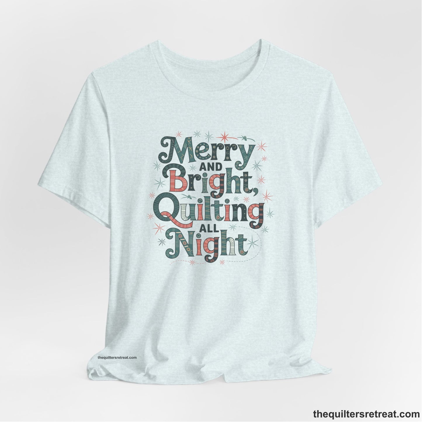A Heather Ice Blue Short Sleeve T-Shirt with a Merry and Bright Quilting All Night text with festive patterns and stars in a whimsical style