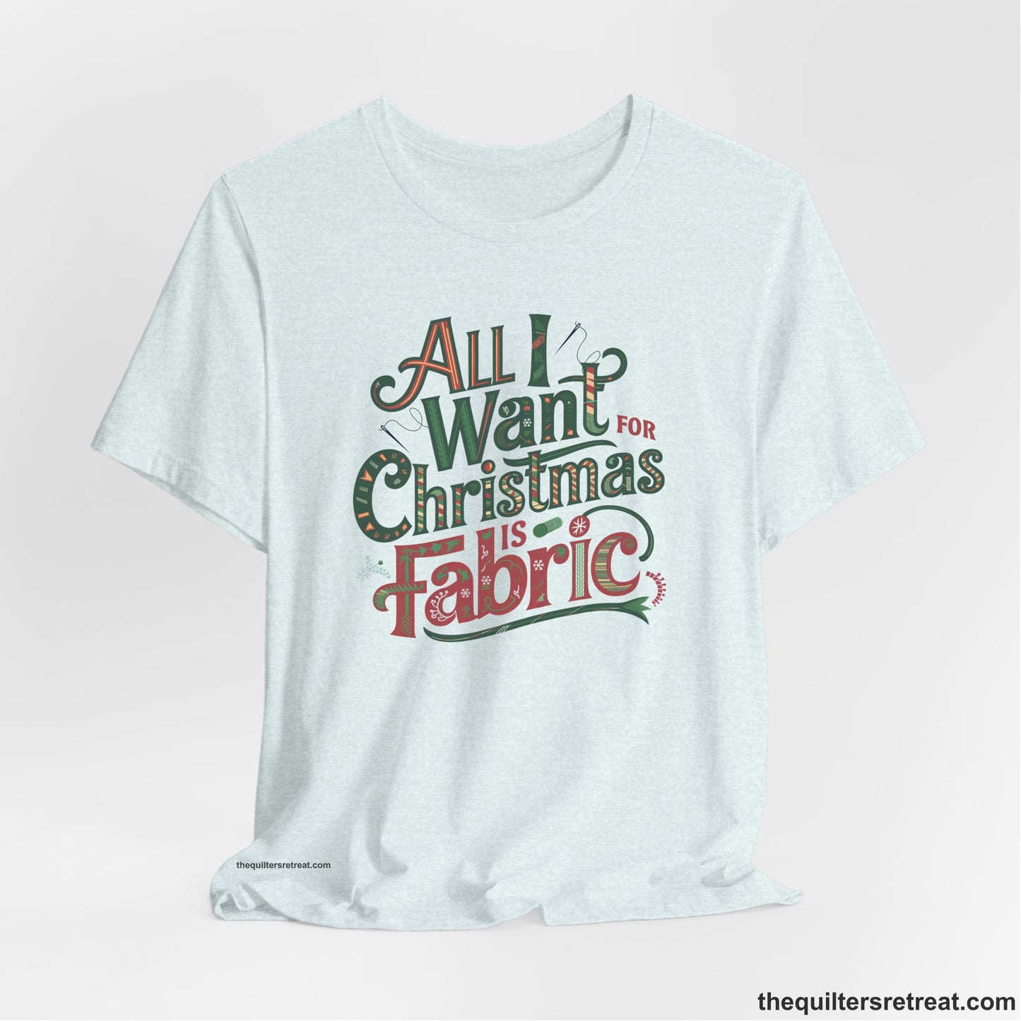 A Heather Ice Blue Short Sleeve T-Shirt with a vintage holiday text "All I Want for Christmas is Fabric" with festive motifs