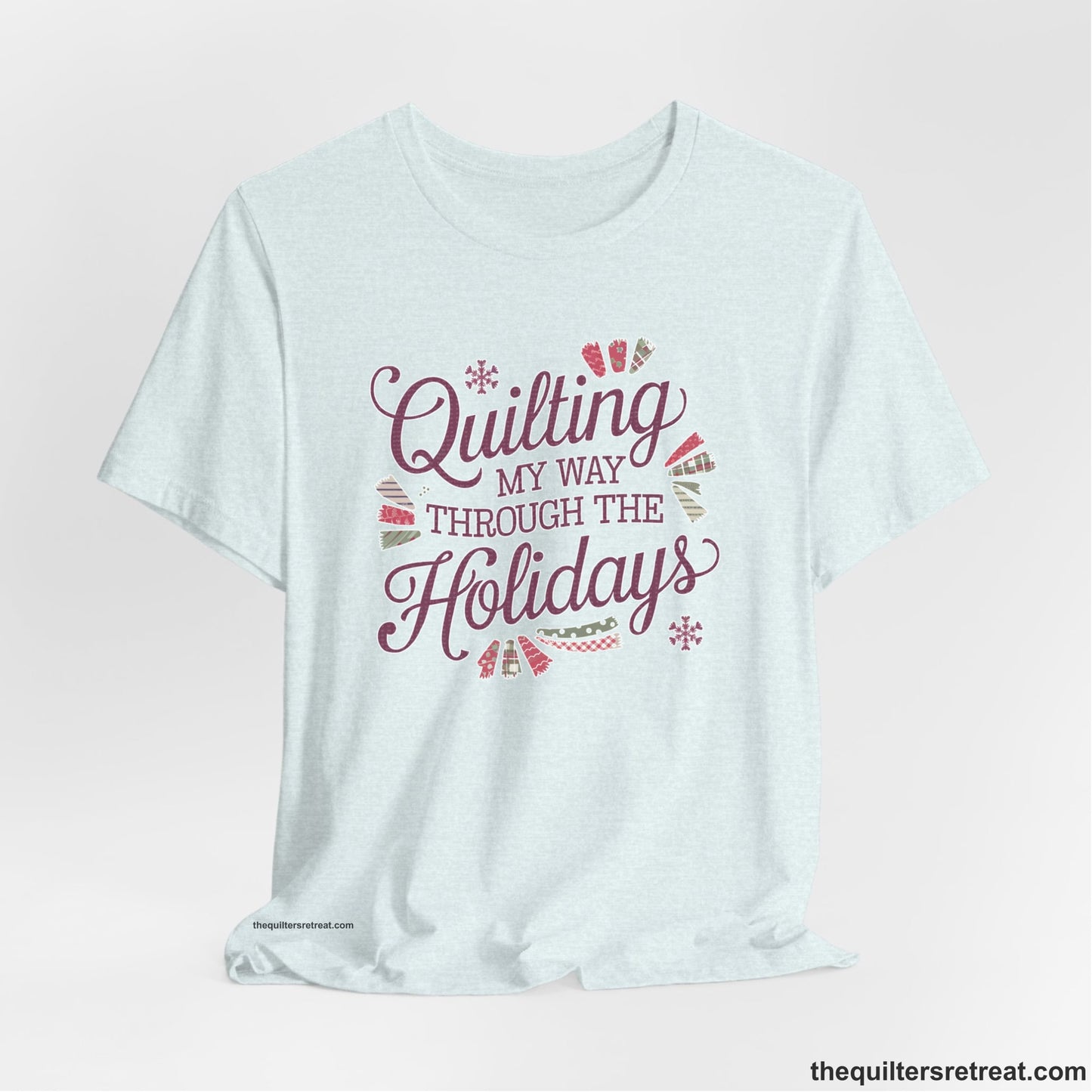 A Heather Ice Blue Short Sleeve T-Shirt with a quilting-themed text in festive colors with decorative quilt patterns