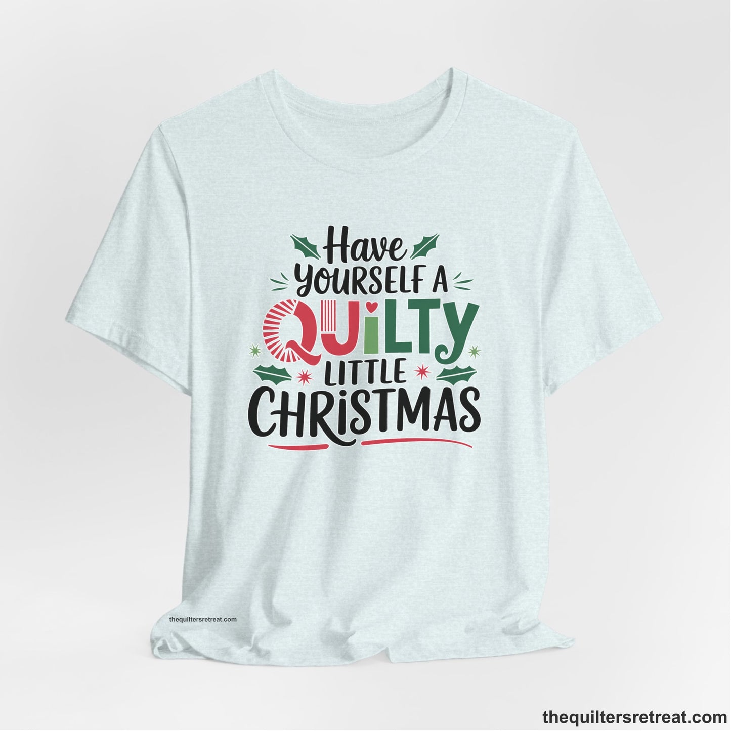 A Heather Ice Blue Short Sleeve T-Shirt with a festive "Have Yourself a Quilty Little Christmas" text with holly and quilt patterns
