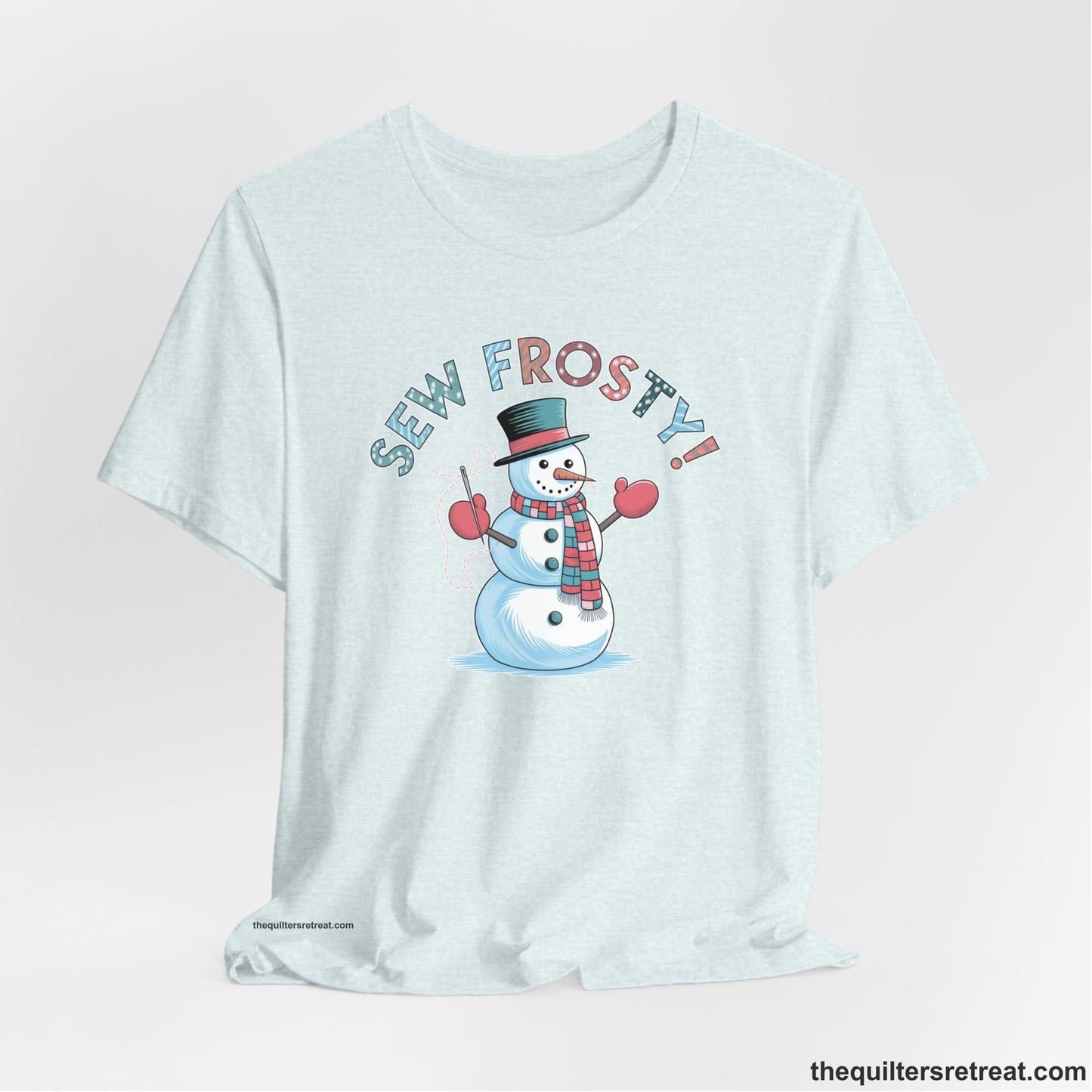 A Heather Ice Blue Short Sleeve T-Shirt with a playful snowman sewing illustration with "Sew Frosty!" text in a festive style