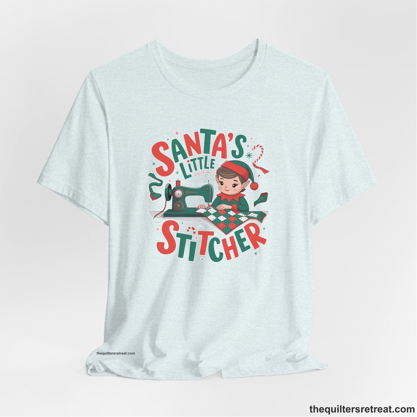 A Heather Ice Blue Short Sleeve T-Shirt with a santa's little stitcher elf sewing quilt with festive colors in playful style