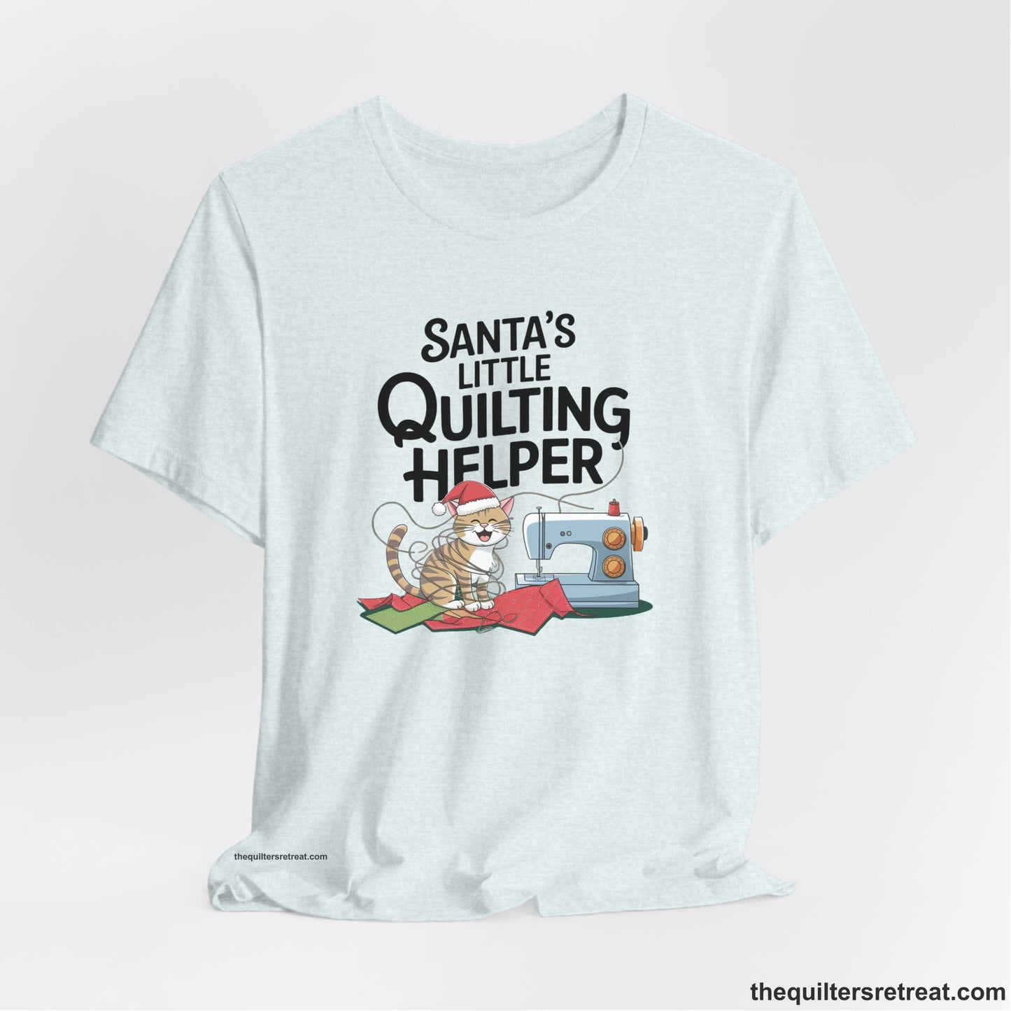 A Heather Ice Blue Short Sleeve T-Shirt with a santa-hat-wearing kitten with a sewing machine and "Santa's Little Quilting Helper" text in playful style