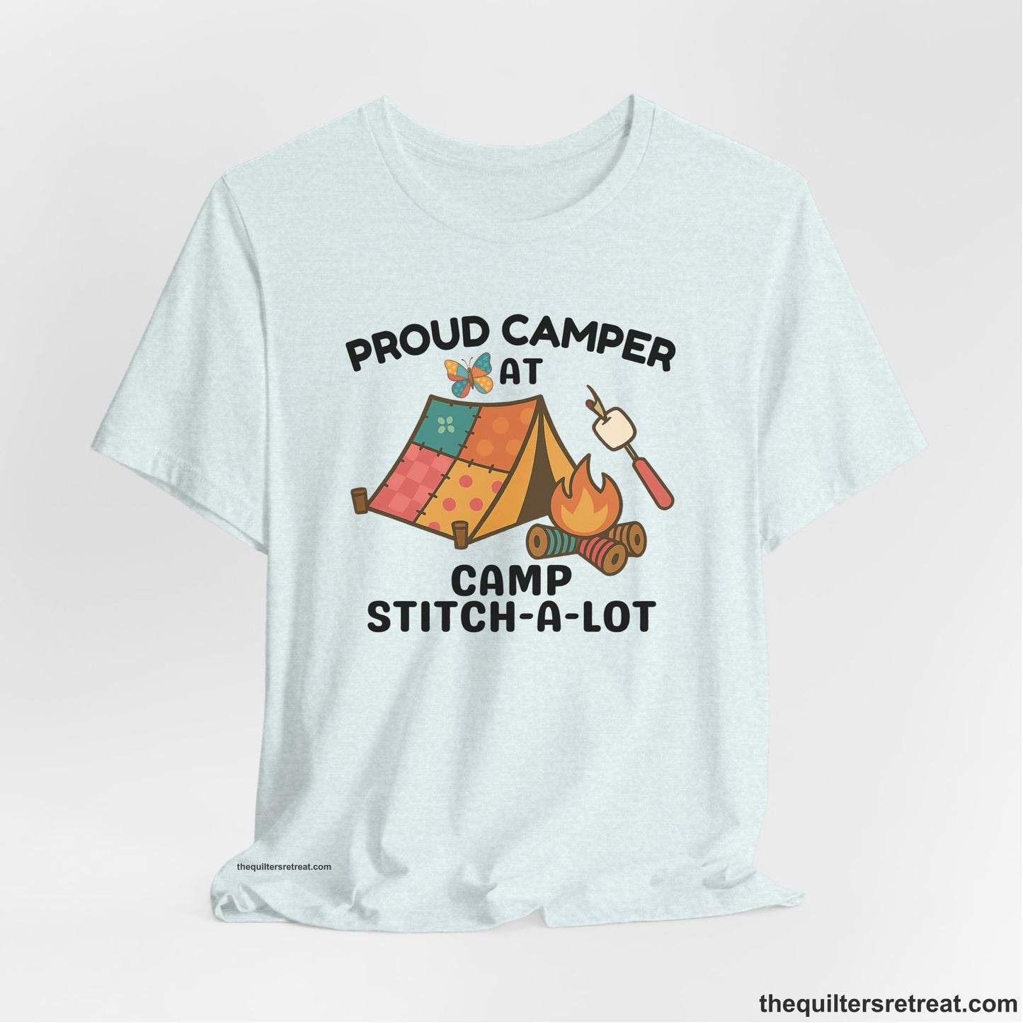 A Heather Ice Blue Short Sleeve T-Shirt with a camping scene with patchwork tent, campfire, and whimsical butterfly and marshmallow illustration