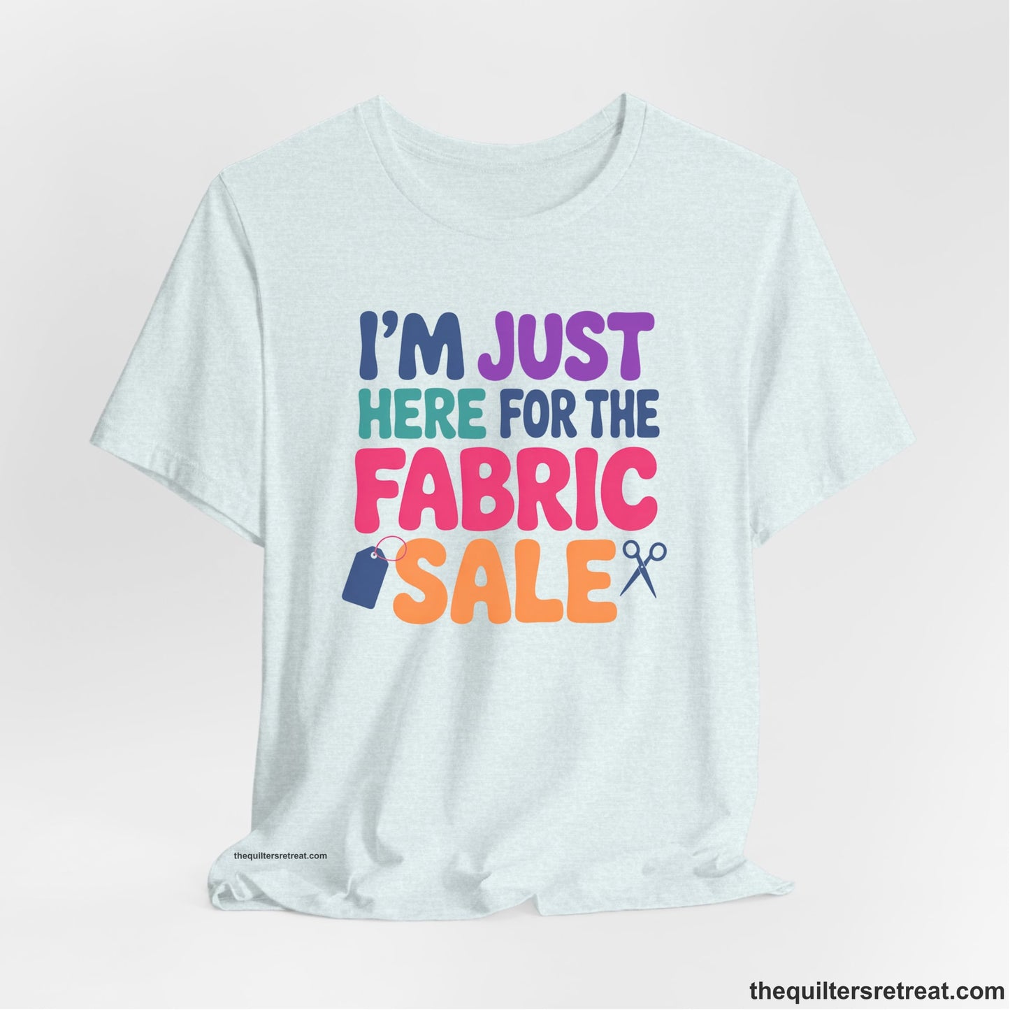 A Heather Ice Blue Short Sleeve T-Shirt with a playful "I'm Just Here for the Fabric Sale" text with colorful letters and sewing icons