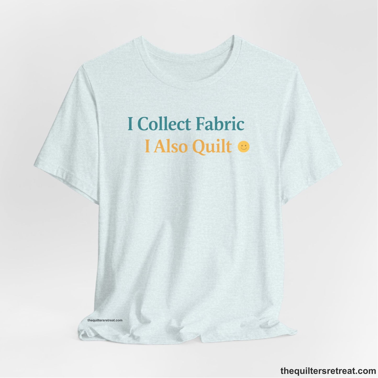 A Heather Ice Blue Short Sleeve T-Shirt with a Colorful text saying "I Collect Fabric I Also Quilt" with a playful, cheerful vibe.