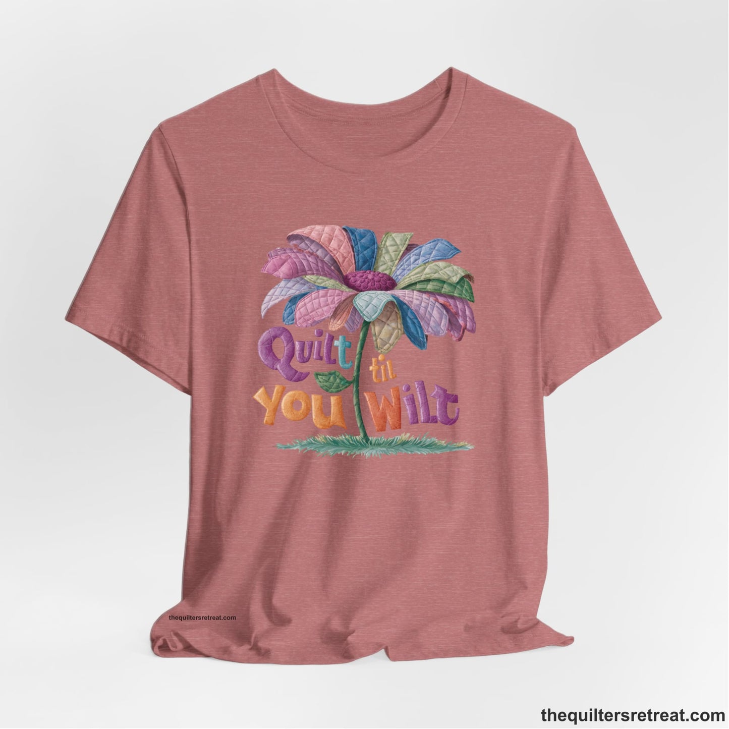 A Heather Mauve Short Sleeve T-Shirt with a whimsical quilted flower with bold "Quilt til You Wilt" text