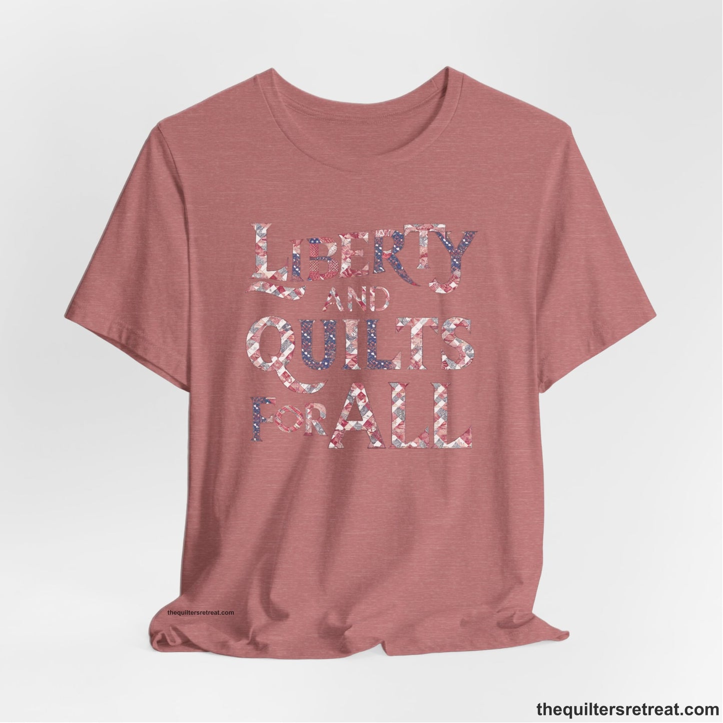 A Heather Mauve Short Sleeve T-Shirt with a Liberty and Quilts for All" text with patchwork quilt pattern in a vintage style