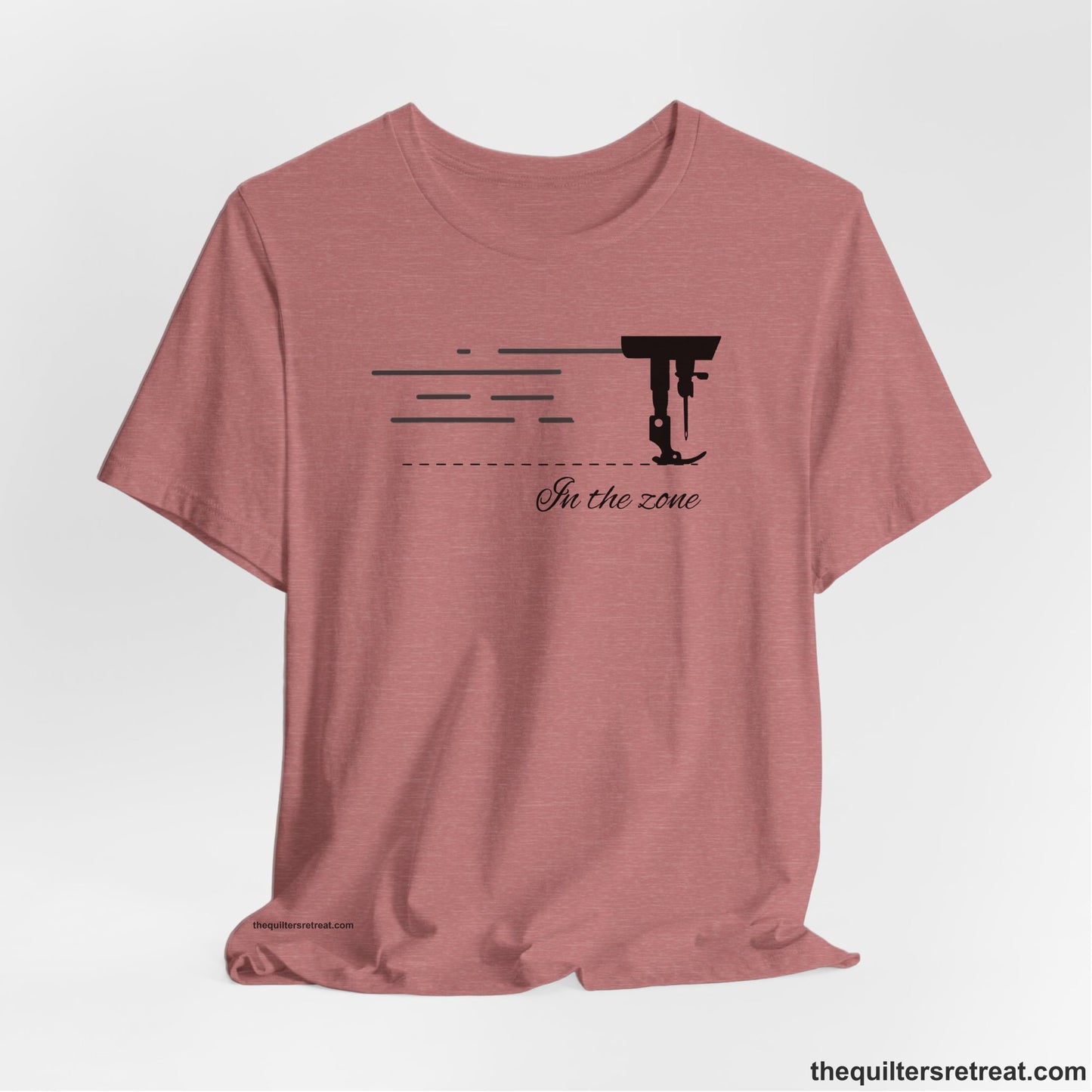 A Heather Mauve Short Sleeve T-Shirt with a vintage sewing machine illustration with floral accents and "Sewing Mends the Soul" text