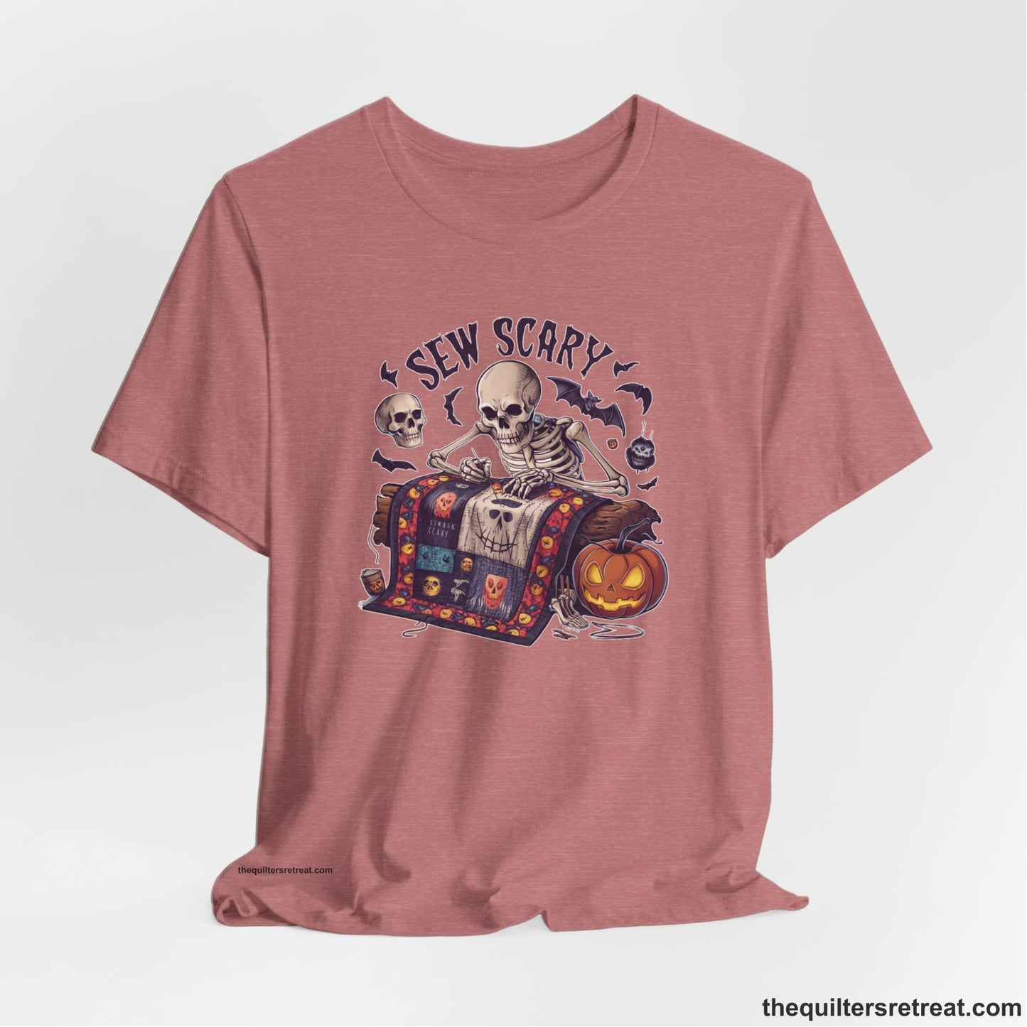 A Heather Mauve Short Sleeve T-Shirt with a skeleton quilting with spooky accents and "Sew Scary" text in a Halloween theme