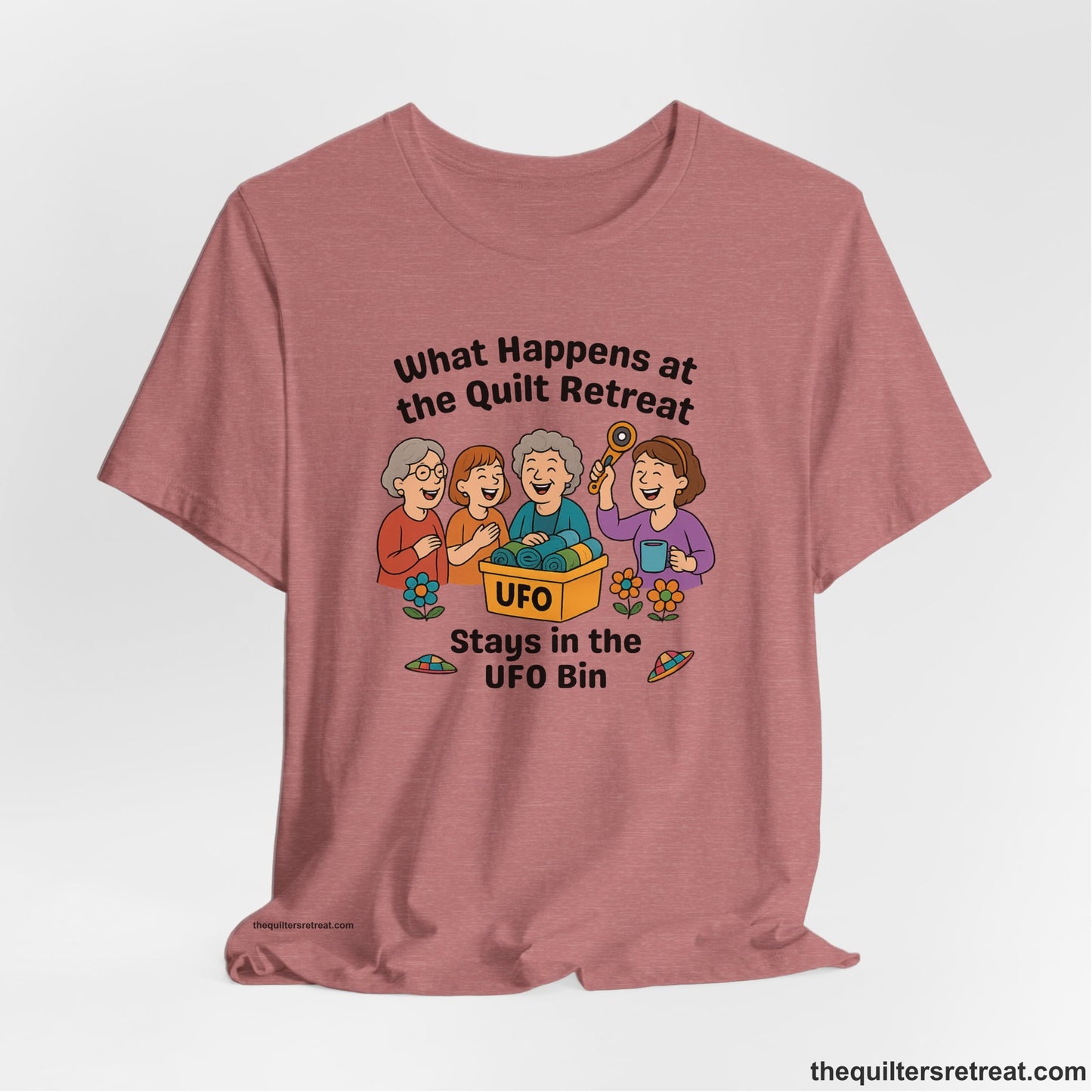 A Heather Mauve Short Sleeve T-Shirt with a four smiling women with unfinished fabric objects and playful "UFO" text in a cartoon style
