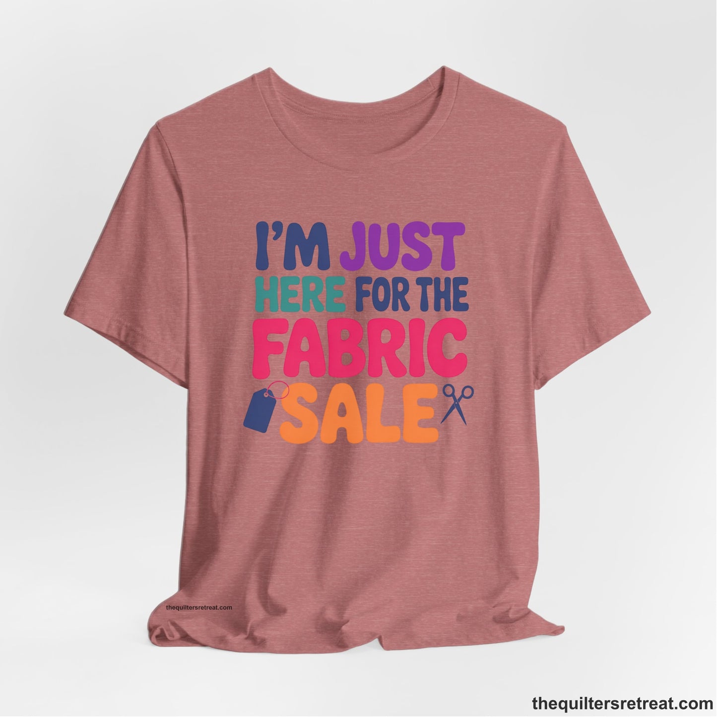 A Heather Mauve Short Sleeve T-Shirt with a playful "I'm Just Here for the Fabric Sale" text with colorful letters and sewing icons