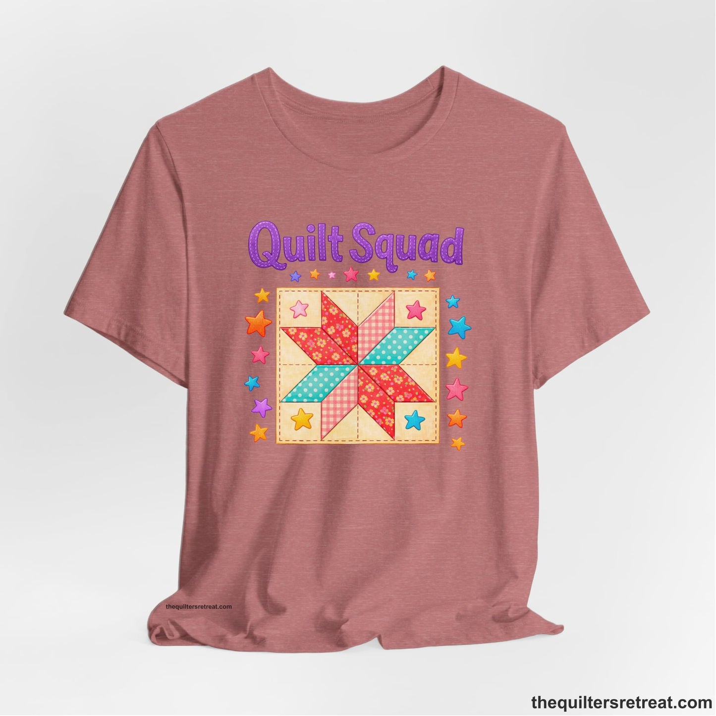 A Heather Mauve Short Sleeve T-Shirt with a Patchwork quilt star with colorful stars, playful mood, "Quilt Squad" text.