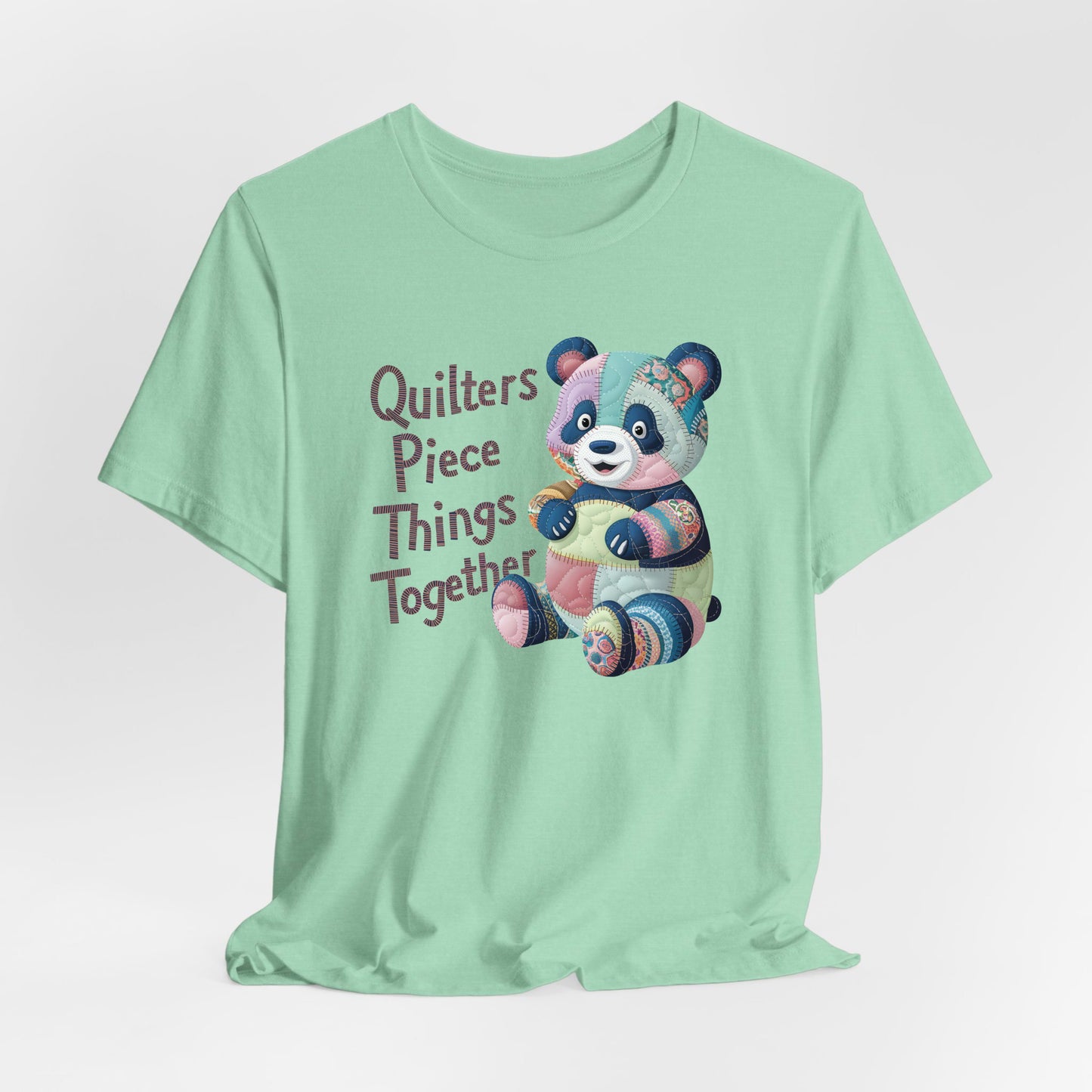A Heather Mint Short Sleeve T-Shirt with a patchwork panda with "Quilters Piece Things Together" text in a whimsical style