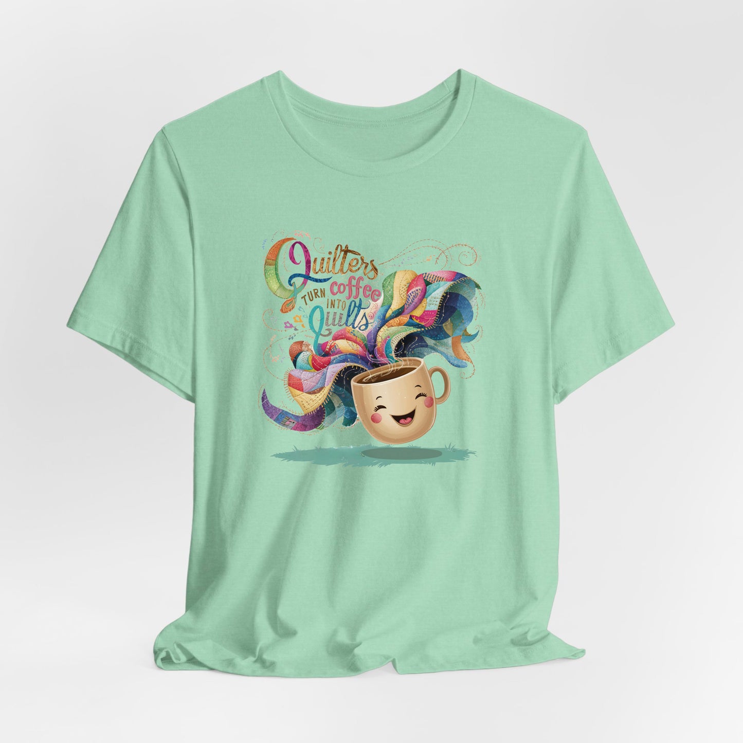 A Heather Mint Short Sleeve T-Shirt with a quirky "Quilters Turn Coffee into Quilts" text with vibrant swirling patterns