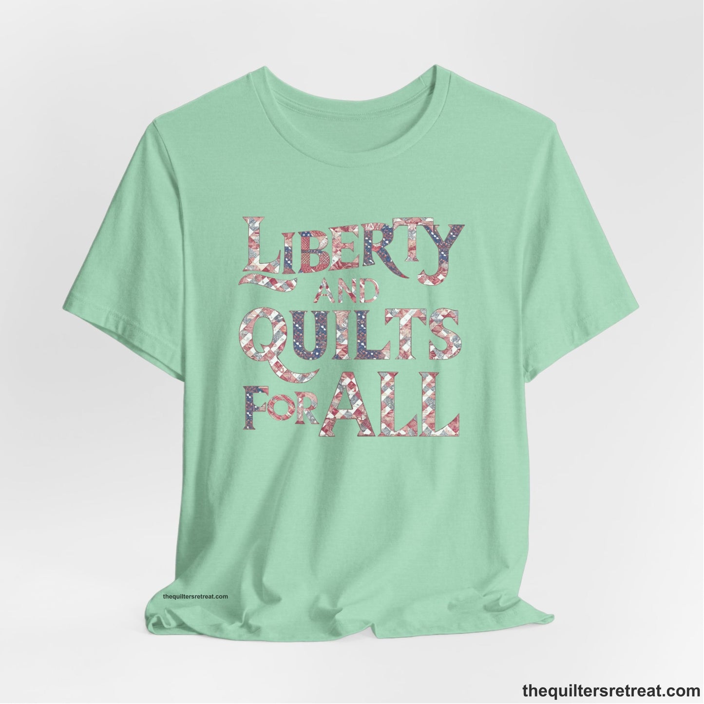 A Heather Mint Short Sleeve T-Shirt with a Liberty and Quilts for All" text with patchwork quilt pattern in a vintage style