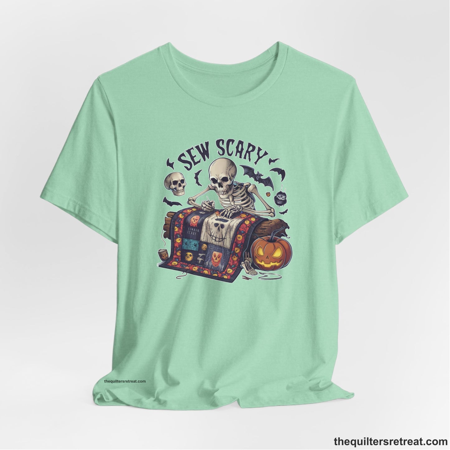 A Heather Mint Short Sleeve T-Shirt with a skeleton quilting with spooky accents and "Sew Scary" text in a Halloween theme