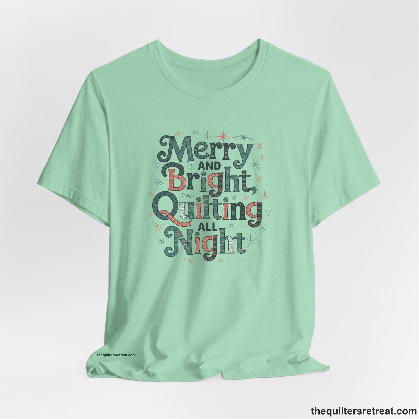 A Heather Mint Short Sleeve T-Shirt with a Merry and Bright Quilting All Night text with festive patterns and stars in a whimsical style