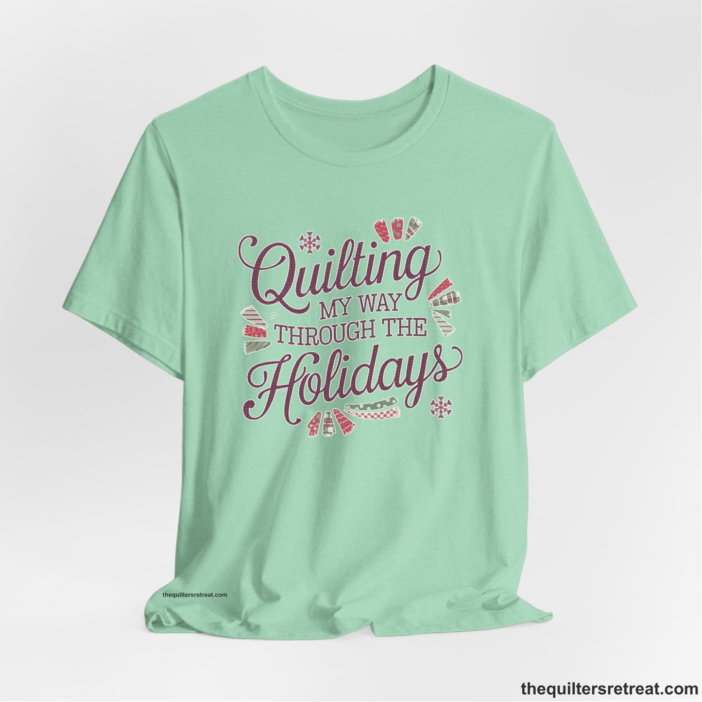 A Heather Mint Short Sleeve T-Shirt with a quilting-themed text in festive colors with decorative quilt patterns