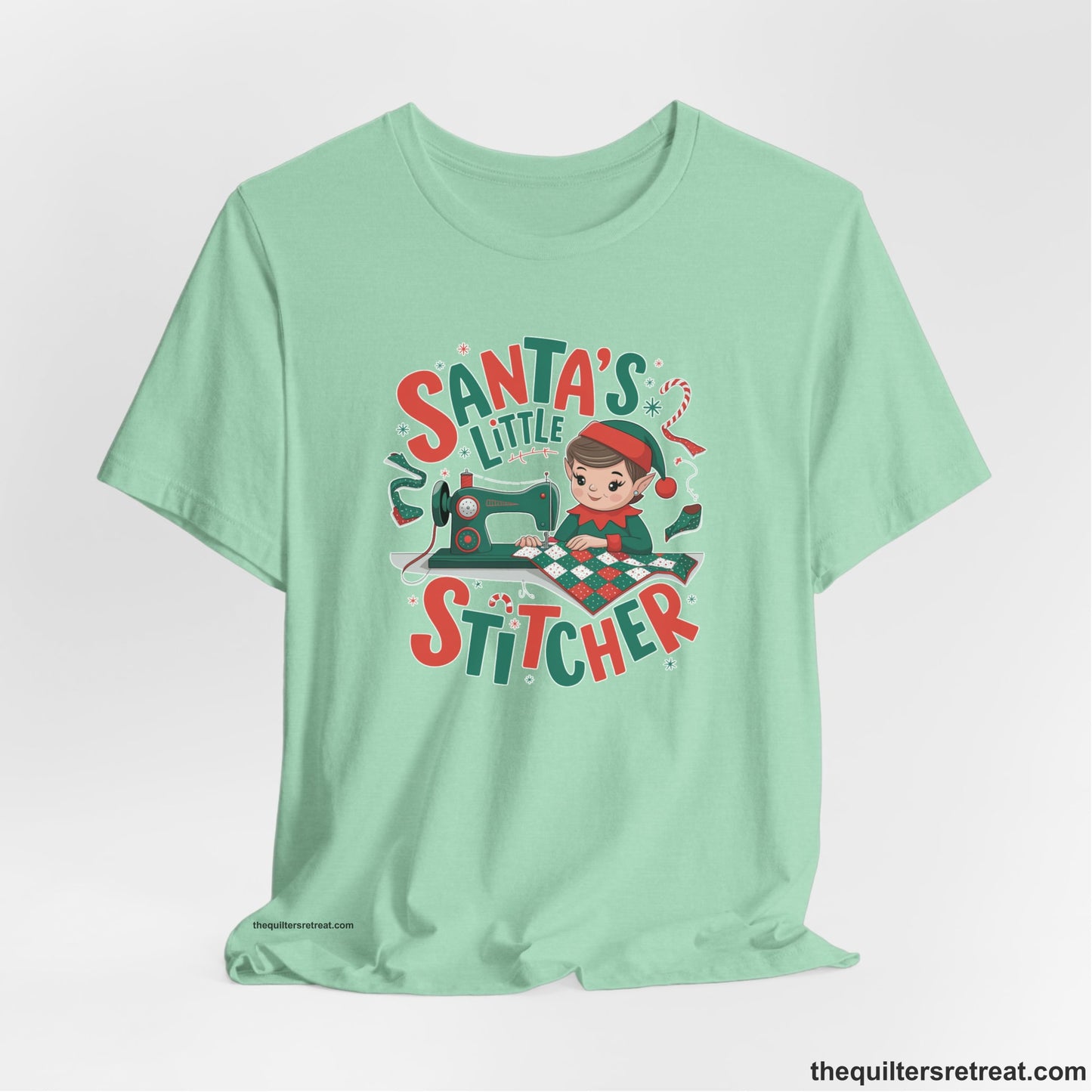A Heather Mint Short Sleeve T-Shirt with a santa's little stitcher elf sewing quilt with festive colors in playful style