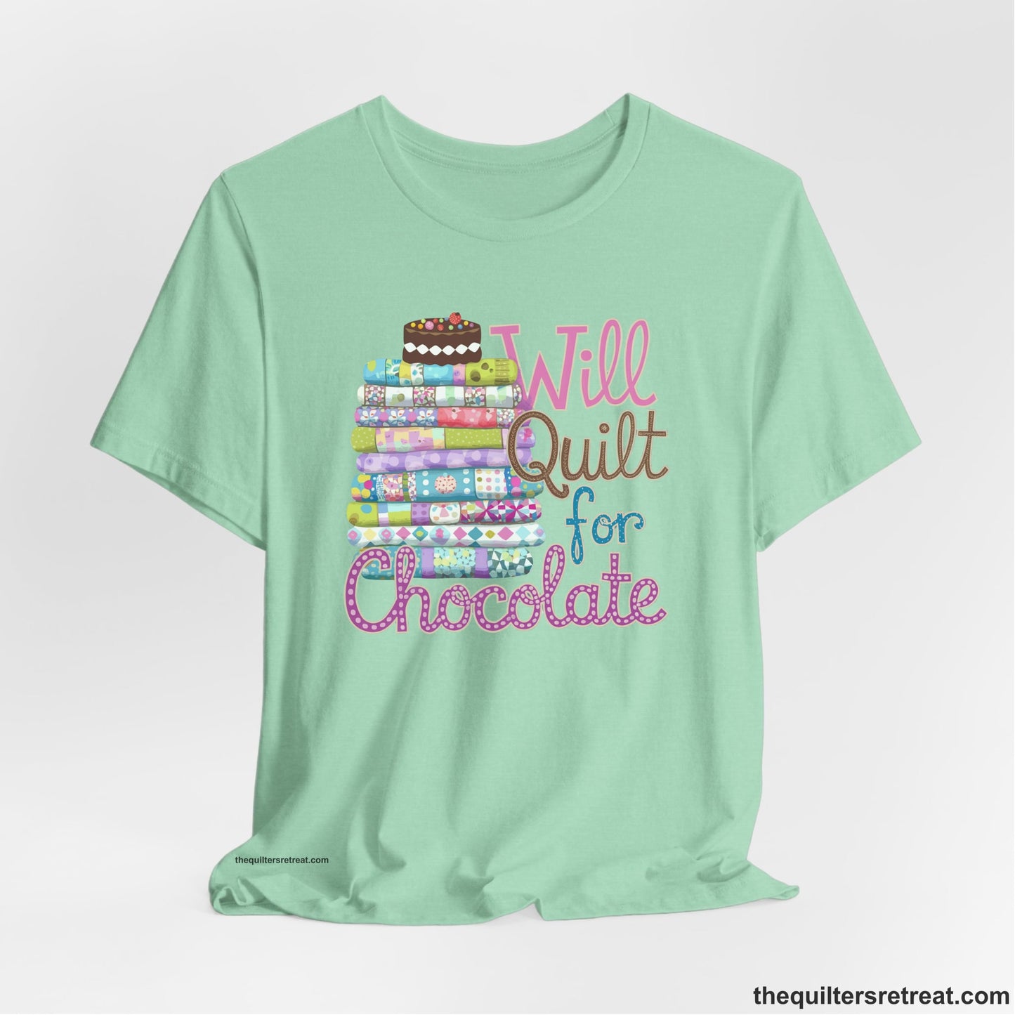 A Heather Mint Short Sleeve T-Shirt with a stack of colorful quilts topped with cake, whimsical "Will Quilt for Chocolate" text