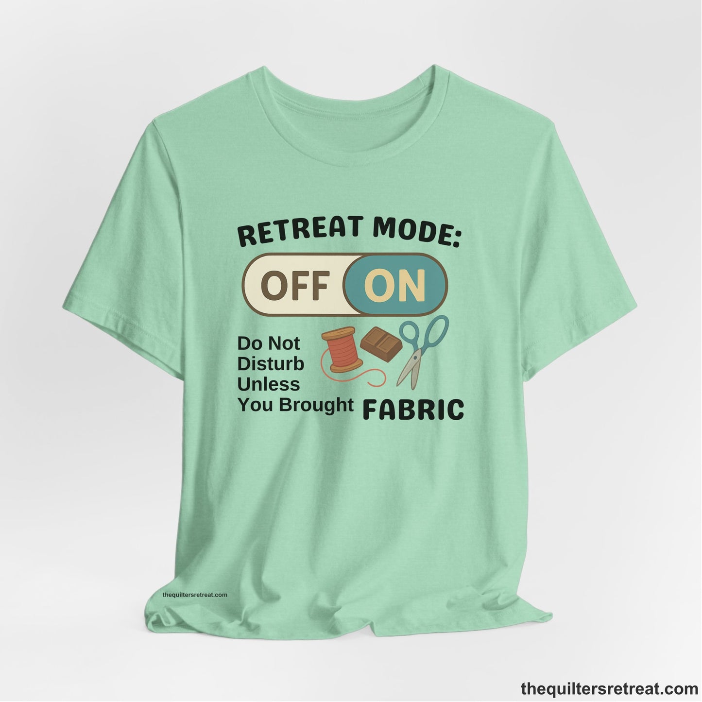 A Heather Mint Short Sleeve T-Shirt with a illustration of sewing tools with a playful "OFF ON" switch design